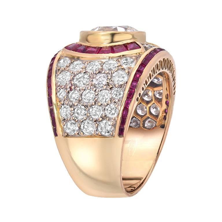 A magnificent ring featuring a 2.50 carat European cut diamond that is bezel set in the center of the piece. There are 2.00 carats of full-cut diamonds and 1.00 carat of deep red rubies set around the center diamond in 18K yellow gold.

Ring size 7.5