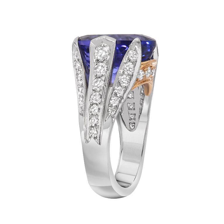 This platinum and gold ring features a 10.88 carat oval shaped tanzanite with a favorable violetish-blue color. Accenting the tanzanite are 1.34 carats of round brilliant cut diamonds set in the shoulders and sides of the ring. A quality piece for a