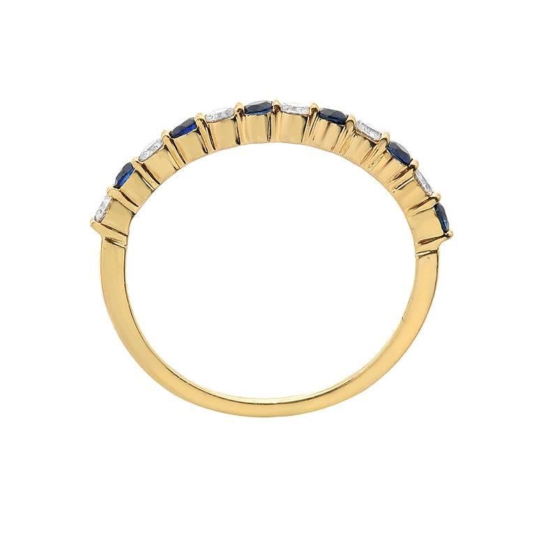 A band ring by designer Gemlok featuring 0.30 carats of precious round cut blue sapphire and 0.30 carats of VS quality round cut diamonds. The alternating gems are set in 18K yellow gold.

Currently ring size 5.25
