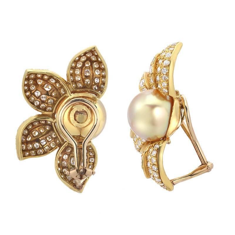 This fun and feminine pair of earrings feature 11.5mm golden south sea pearls in the center of a gorgeous sunflower. The petals are set in 18K yellow gold and are set with 4.80 carats of top VS quality round cut white diamonds.  The backs are clip