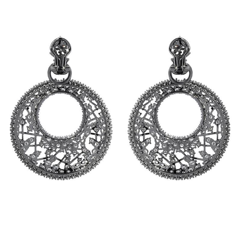 An exquisite pair of earrings reminiscent of dream catchers. These unique earrings feature 15.62 carats of VS quality round cut diamonds, set in 18K white gold with a black rhodium finish and omega clip backings.

Earring Length: 2.20 inches
Earring