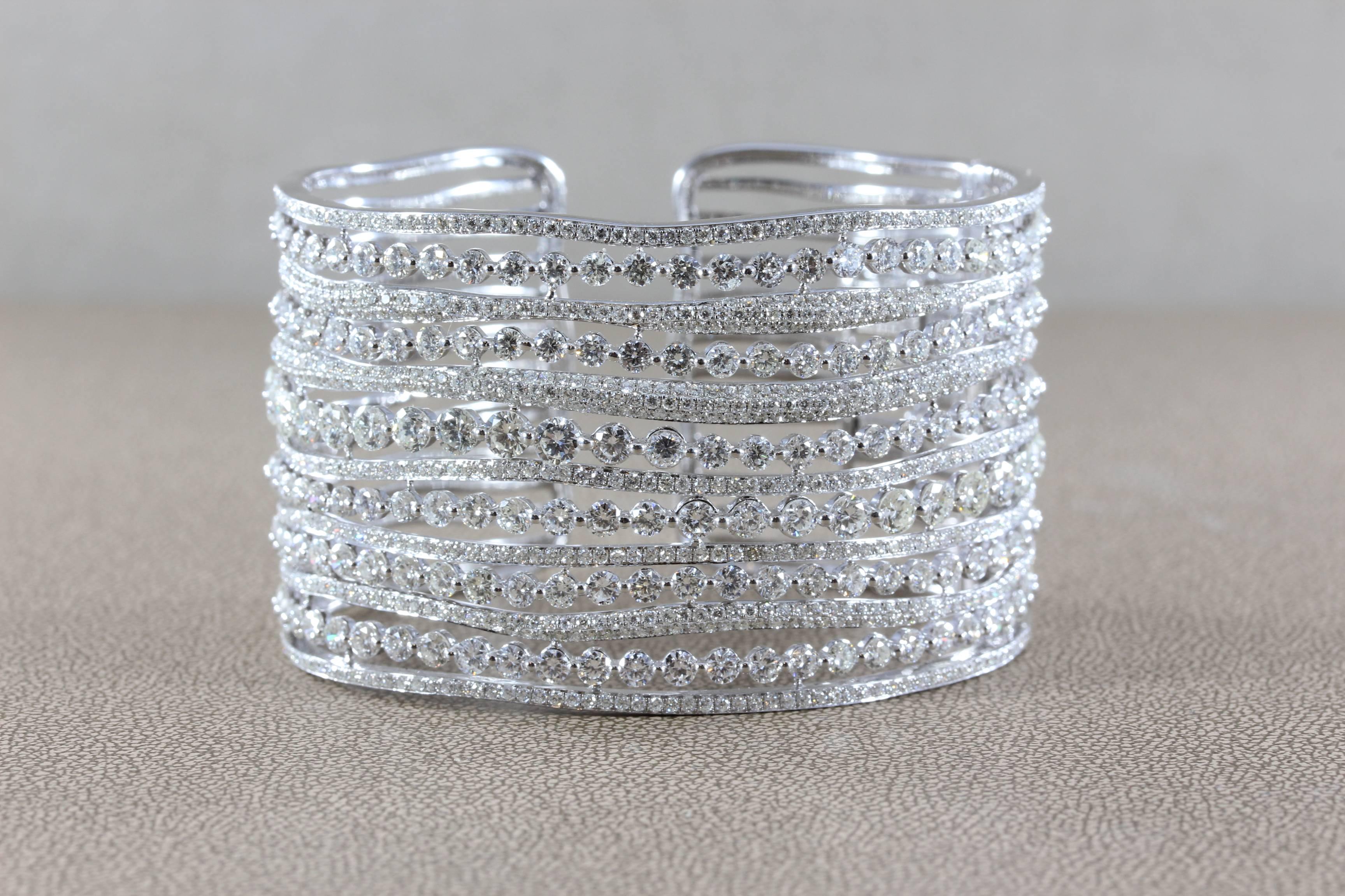 This luxurious cuff bracelet features just under 27 carats of round cut diamonds, both traditionally and pave set in 18K white gold. With over 10 rows of round cut diamonds totaling close to 27 carats, this bracelet is superb. 