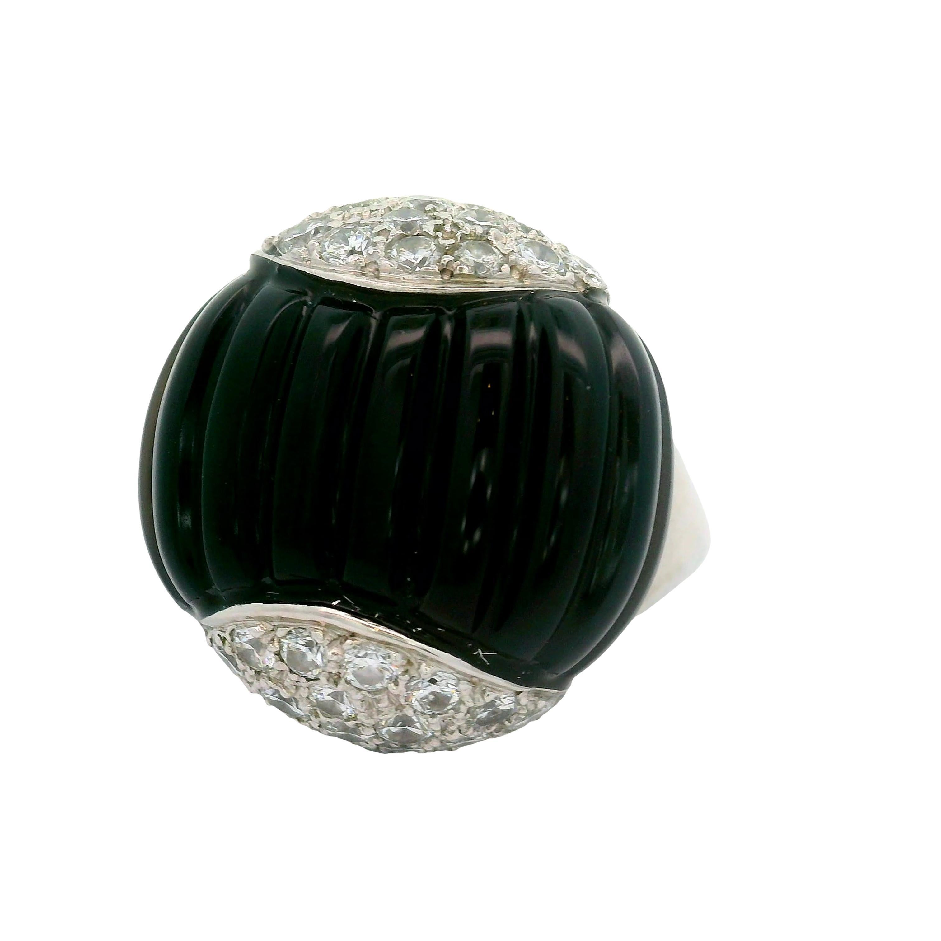 A striking fashion ring featuring a hand polished piece of black onyx, weighing 21.3 carats, commands attention with its deep black color. Accentuating the onyx are round-cut white diamonds, totaling 1.75 carats, adding great contrast and a touch of