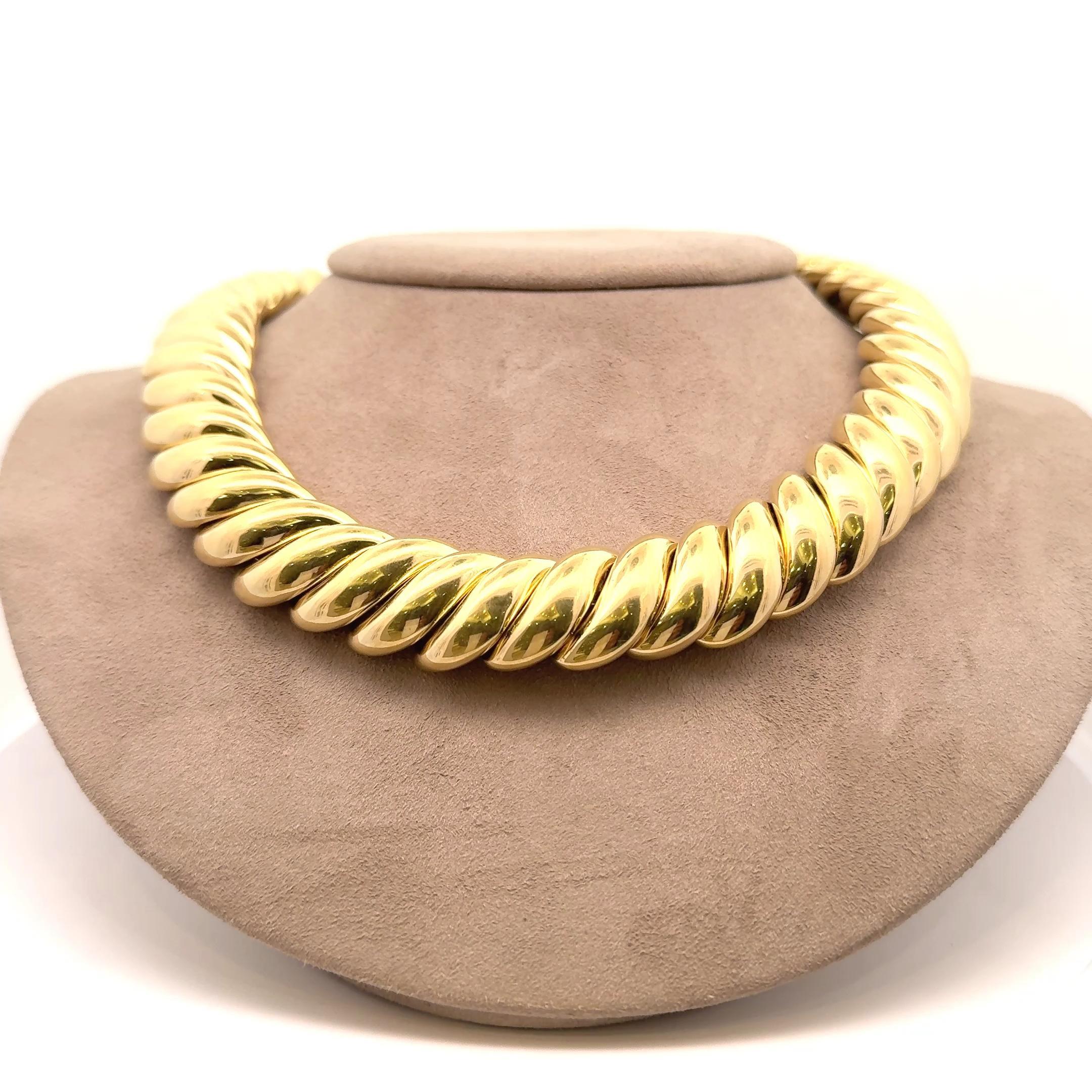 Questa straordinaria collana a maglie mostra un design audace e attorcigliato realizzato in lussuoso oro giallo 18 carati. Il pezzo emana un'eleganza contemporanea, con ogni anello che si incastra senza soluzione di continuità per formare un cerchio