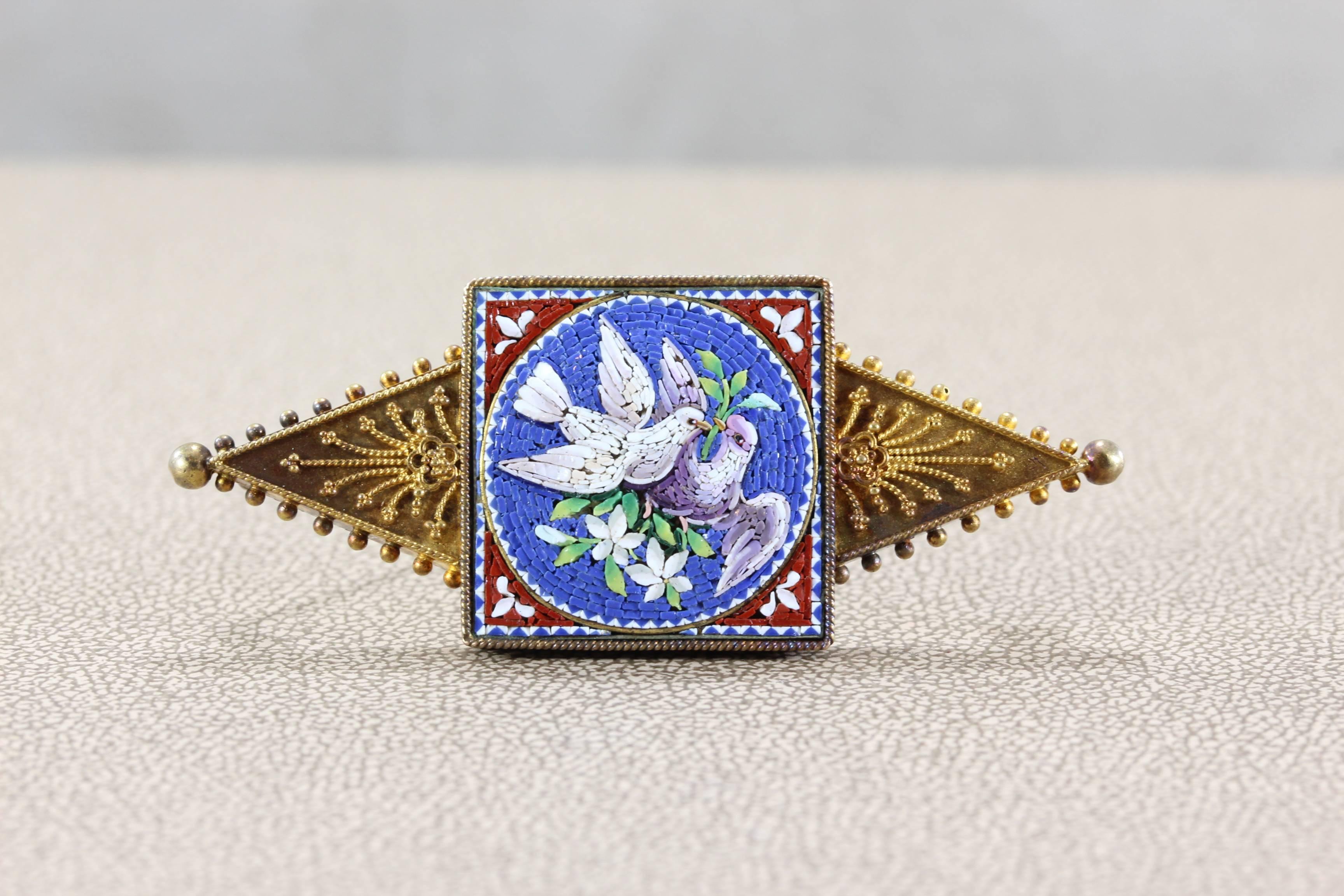 A splendid quality example of micro mosaic work in the Victorian era, most likely crafted in Rome. In fine condition, the mosaic depicts two doves nesting their home with flower branches. The fame is make in 14K gold with scroll motifs and milgrain