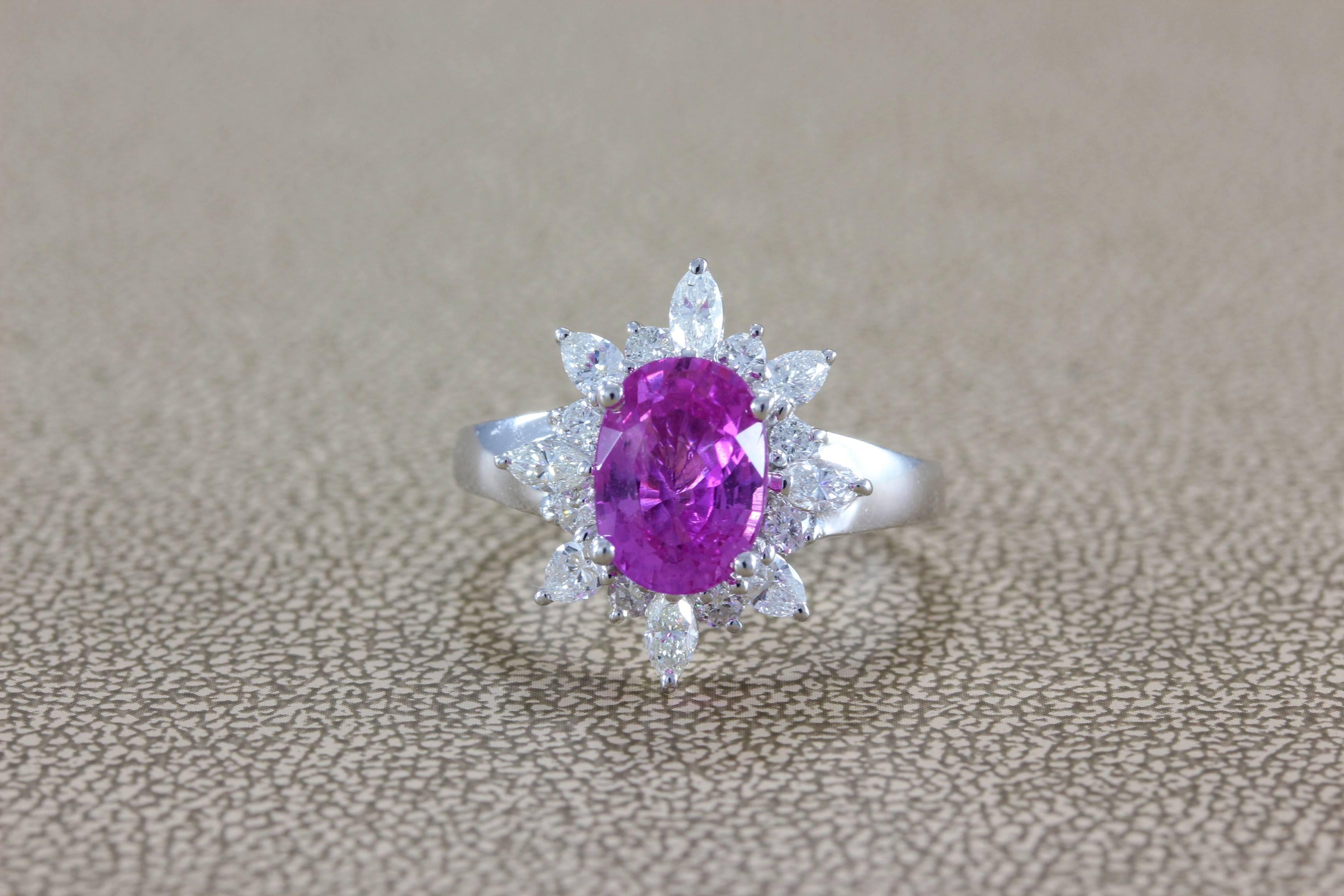 This ring features a true gem 2.74 carat oval shape vivid pink sapphire with strong color saturation. Accenting the center stone and creating a halo around the sapphire are 0.83 carats of round and marquise shape diamonds, all set in 18K white gold.