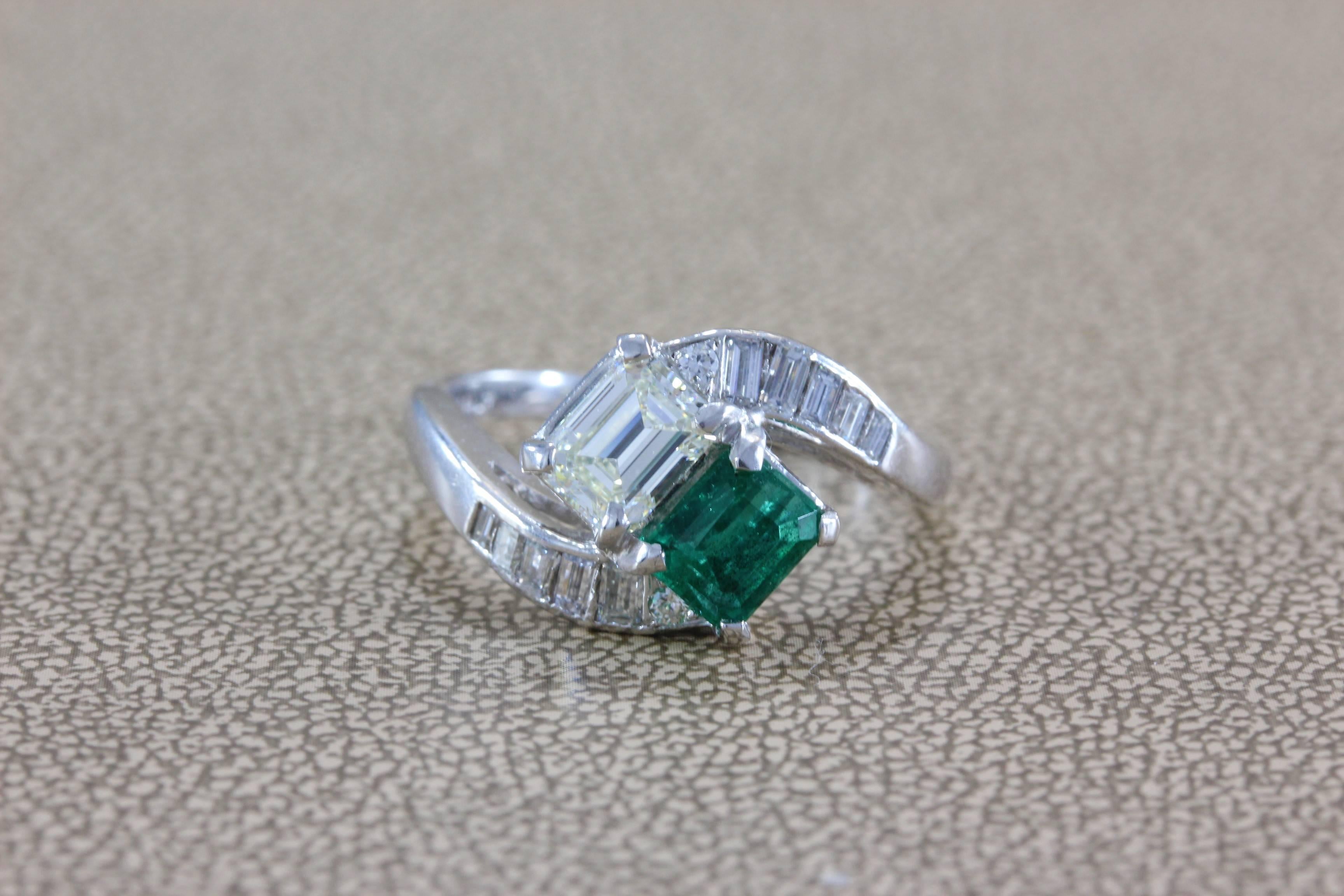 A sleek bypass ring featuring a 0.70 carat emerald cut diamond and a 0.60 carat vivid green emerald, which are complemented by 1.10 carats of baguette cut diamonds set in the shoulders of the ring in platinum. 

Size 6.5 (sizable)

