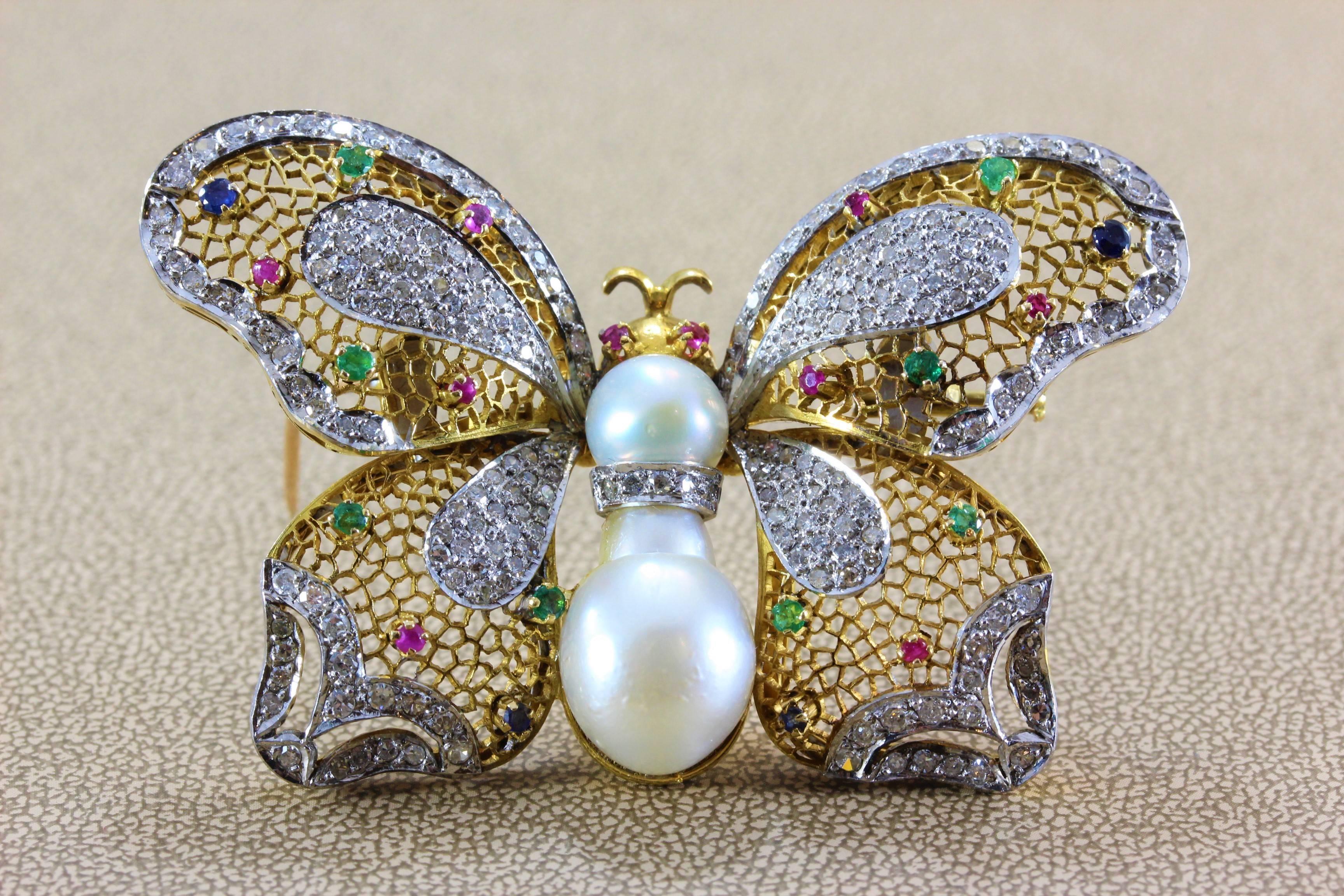 A proud butterfly featuring 2.45 carats of diamonds and studded with 0.70 carats of multi-colored gemstones including ruby, sapphire and emerald. Two fresh water pearls act as the body of the beautiful butterfly. Gems set in 18K yellow gold.