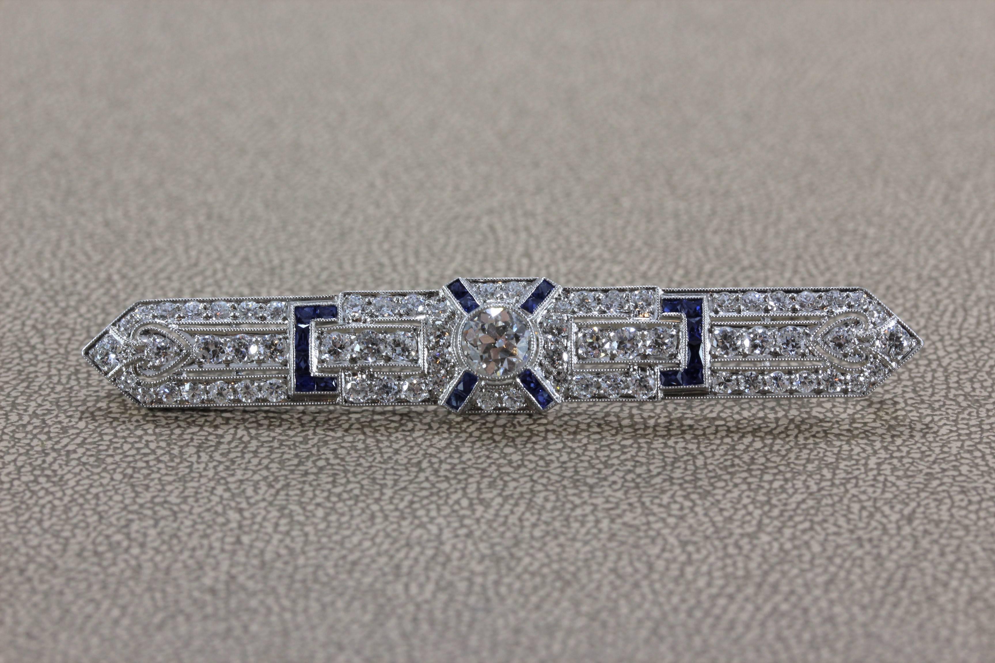 A superb Art Deco diamond and sapphire bar pin featuring a center diamond weighting approximately 1 carat. Around the center diamond are 4 carats of old cut diamonds and blue sapphire, set in platinum. A brooch from the early 20th century with a