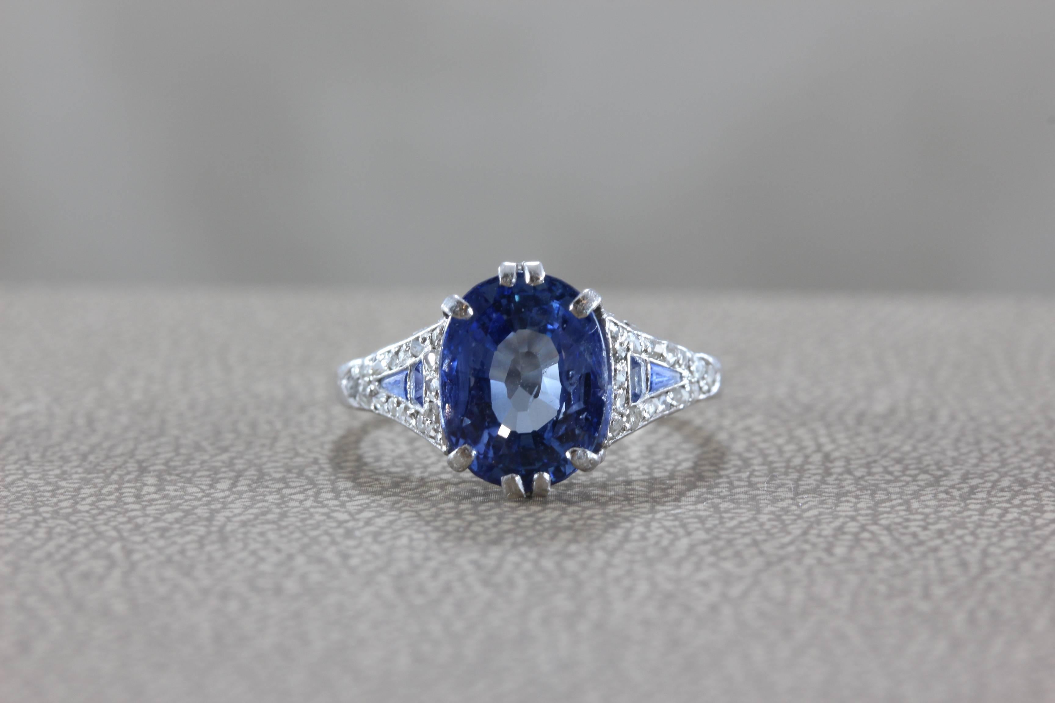 A Mauboussin classic, this platinum set ring features a 3.15 carat oval shape blue sapphire. Accenting the center sapphire are diamond and sapphire accents. 

The Parisian jewelers are known for their bright colored gemstones. 

Size 5 3/4