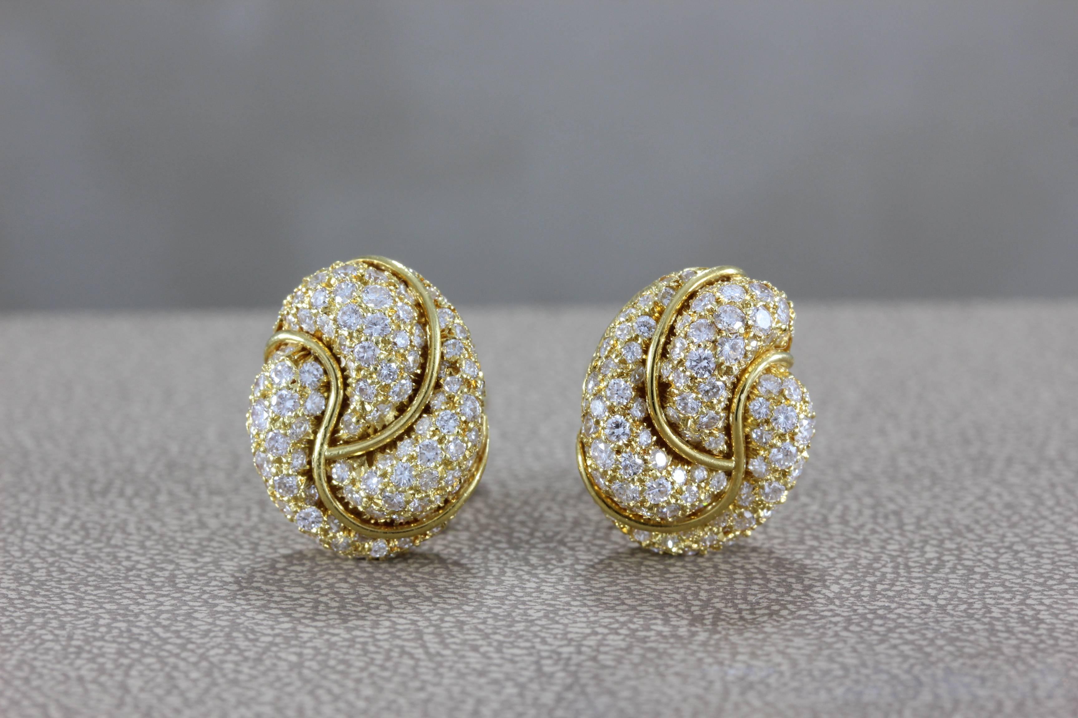 A classic Henry Dunay piece, these ear clips feature approximately 3 carats of round cut VS diamonds set in 18K yellow gold in a spiral swirl design. A fine American jewelry house, these Henry Dunay earrings are a timeless classic. 

Dimensions: