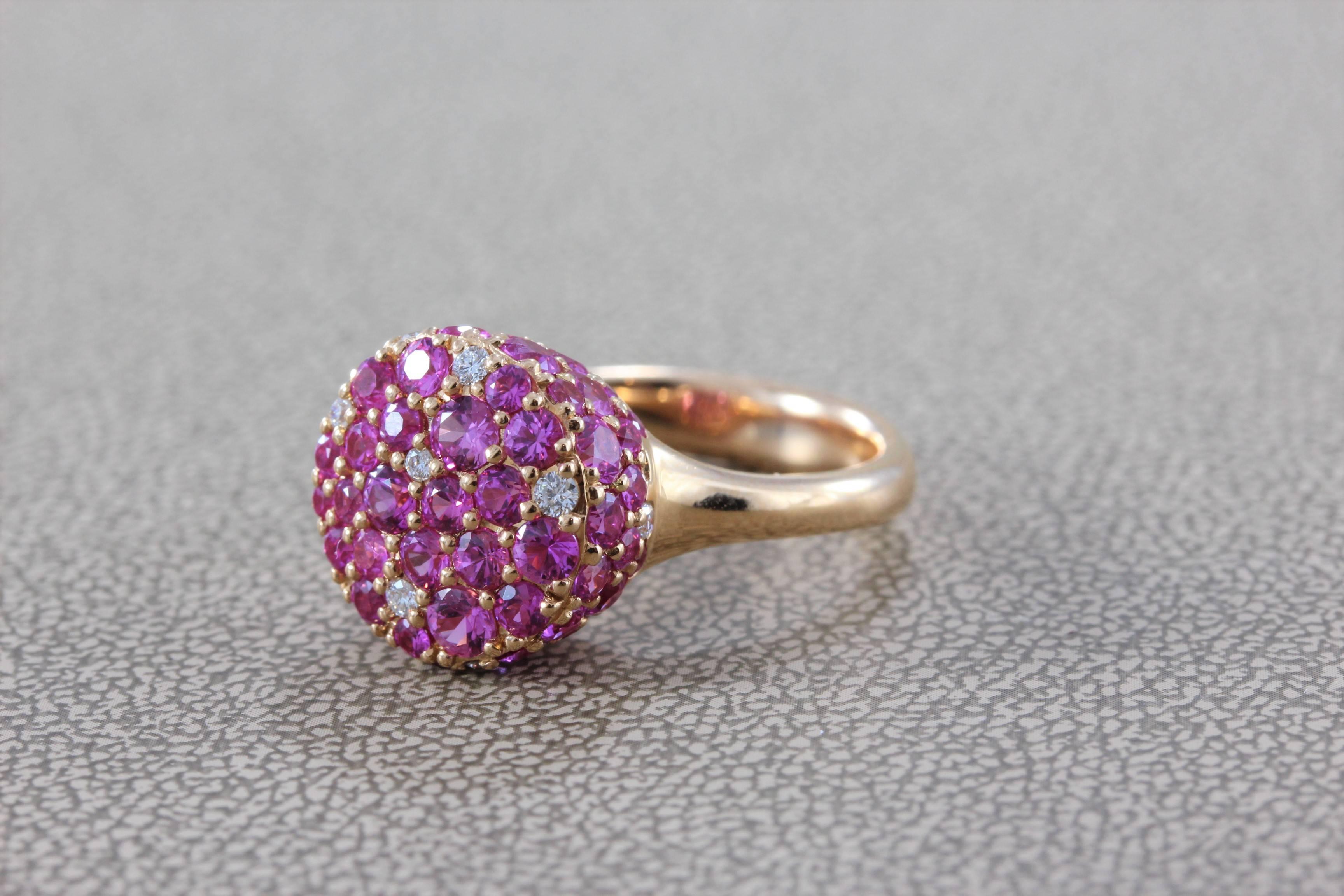 A beautiful display of sparkle and light irradiate from this unique ring. It features over 3 carats of vivid pink round cut sapphire and diamond accents. Set in 18K rose gold, a perfect ring that can be worn everyday. 

Size 6 ½ 
