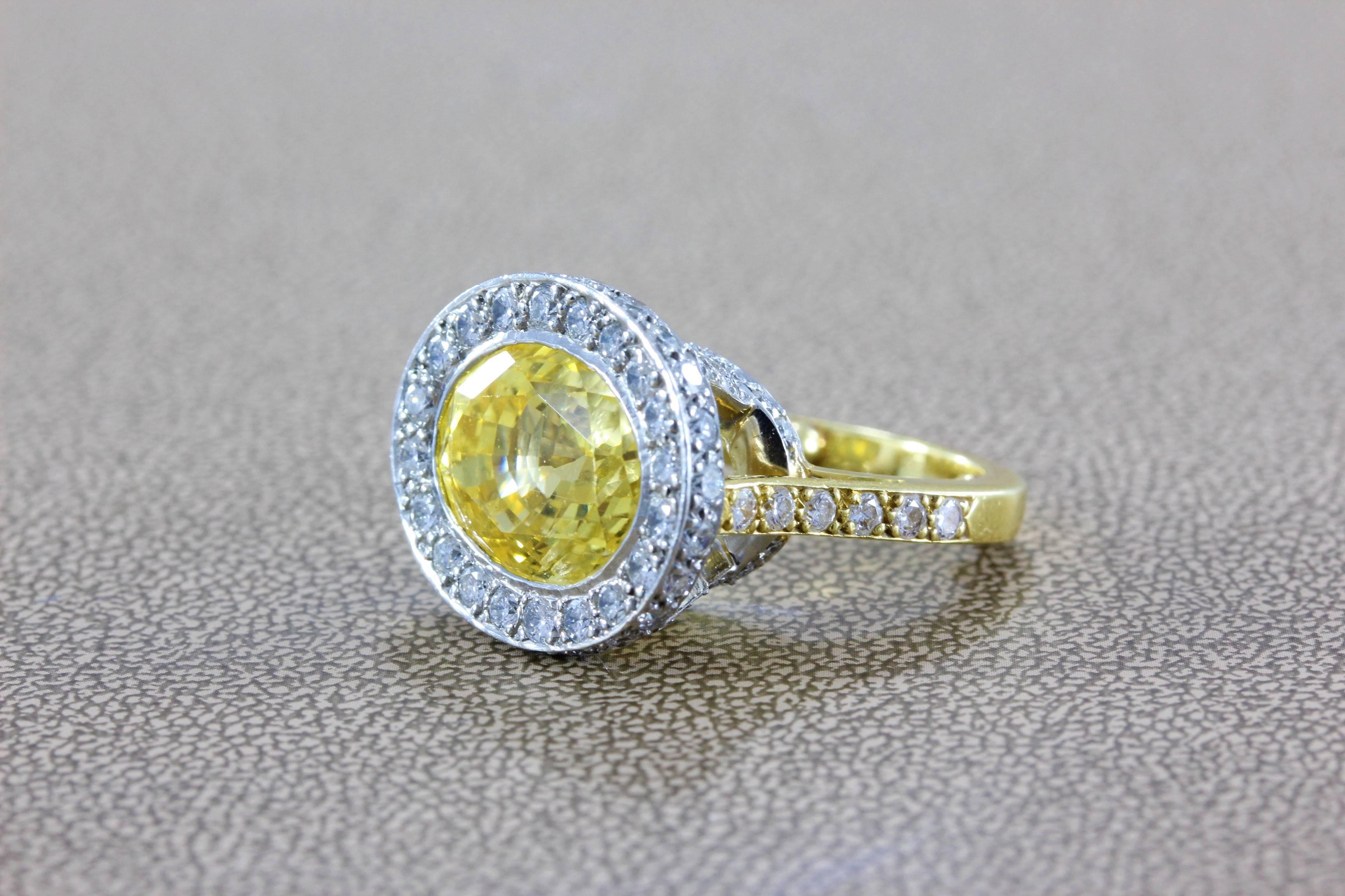 This lovely cocktail ring features a natural No Heat 13.61 carat oval shape yellow sapphire of fine gem quality, bezel set in platinum and 18K yellow gold. Just under 2 carats of VS quality round cut diamonds are set around the ring and give the