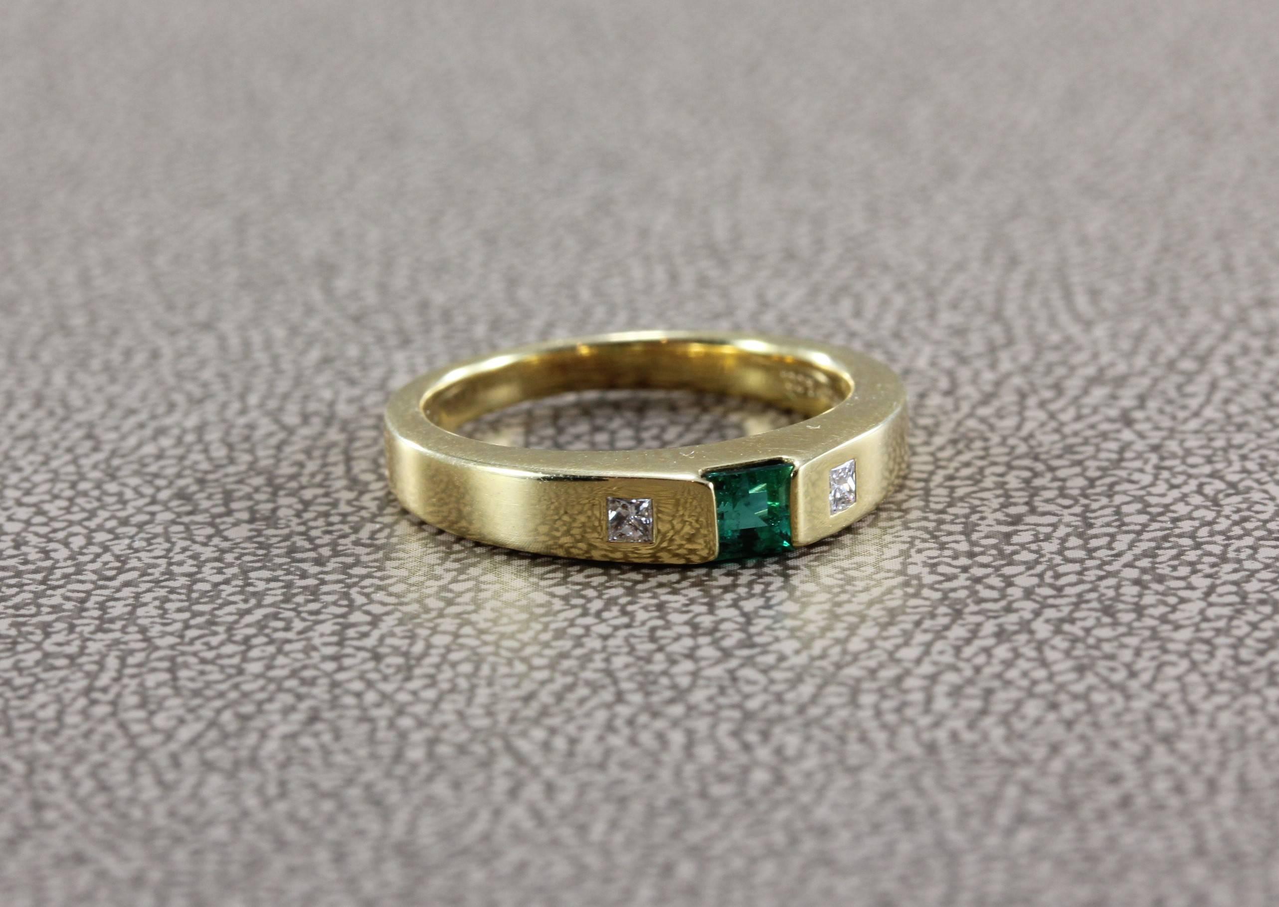 A Tiffany & Co. original, this band ring mains a vivid green emerald with two princess cut diamonds bezel set in 18K yellow gold. A quality made piece of jewelry by the famed Tiffany house, great for everyday wear and as a gift. 

Ring Size 5
