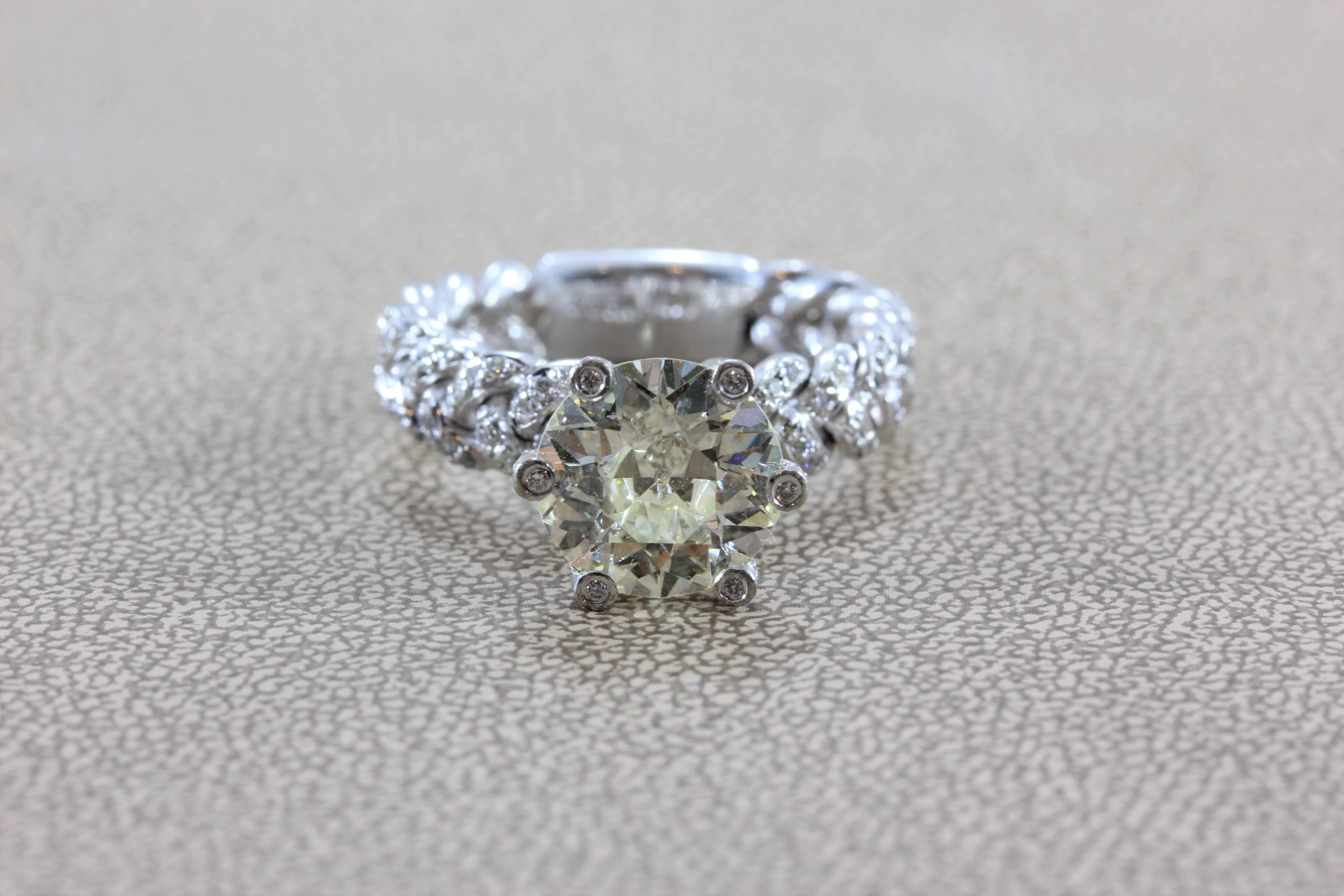 A wonderfully unique engagement ring featuring a 3.50 carat round European cut diamond that has amazing fire and brilliance. It is set in a white gold 6 claw prong setting, which have diamonds set in them. Diamonds are set across the braided