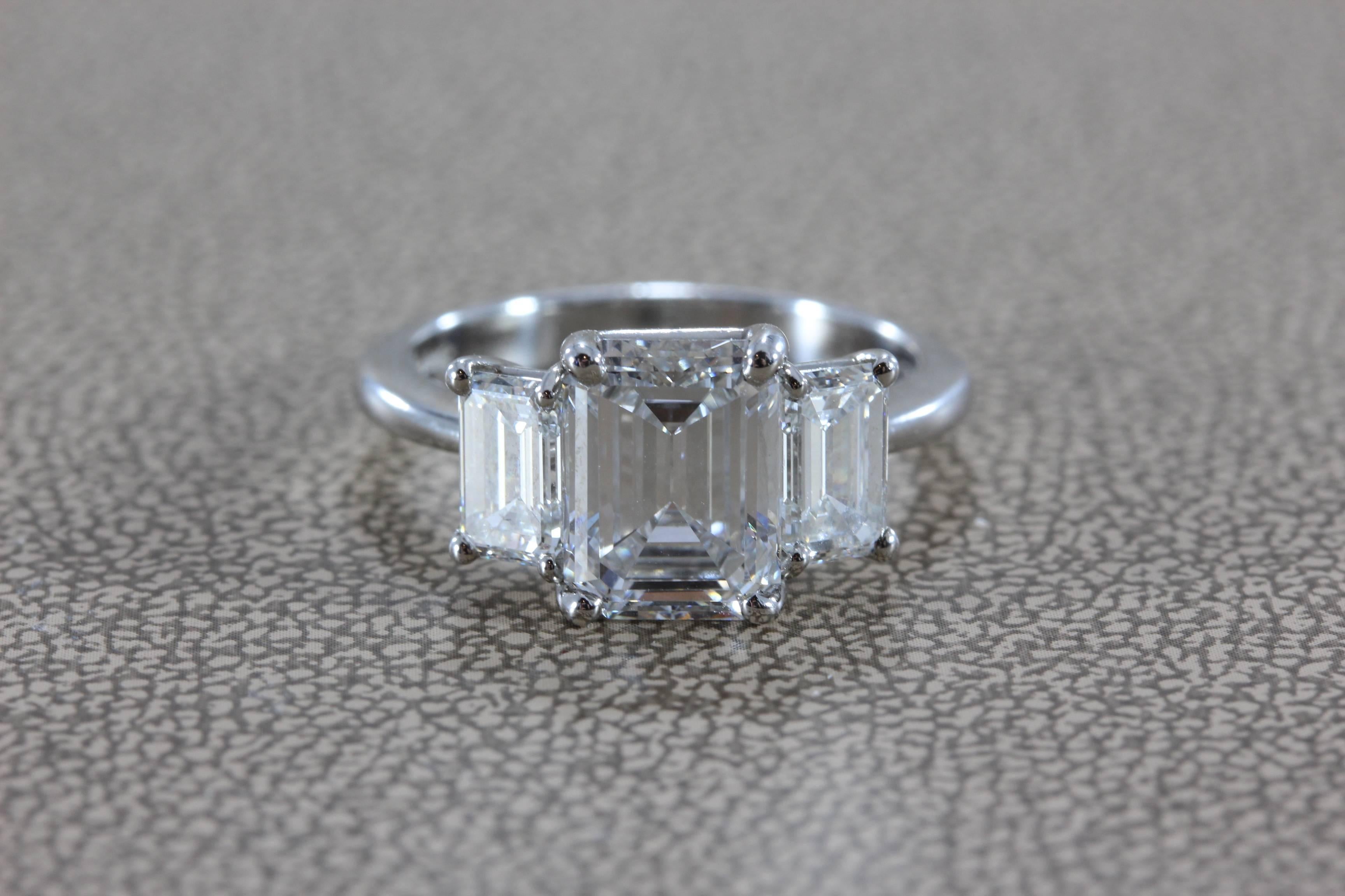 This luxurious engagement ring features a top quality 2.28 emerald cut diamond with E color and VVS2 clarity. The diamond is beautifully cut with excellent proportions and no florescence, a true top-grade gem of a diamond. There are two smaller