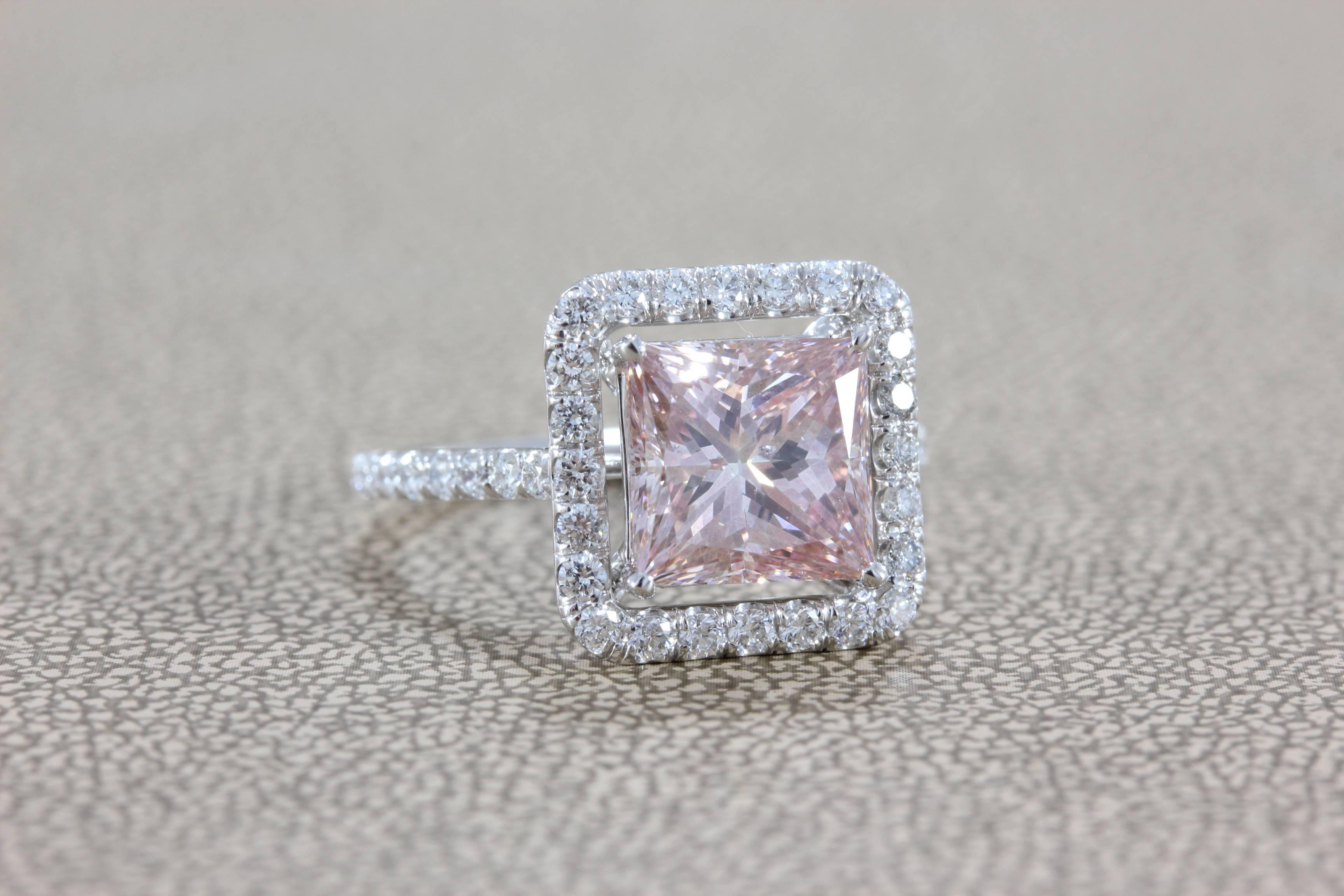 A femininely designed 3.02 carat fancy pink princess cut diamond is set with 0.90 carats of VS quality round cut diamonds. This special diamond is set in 18K white gold.  

This diamond has not been tested for origin of color.

Ring size 5 ½ 