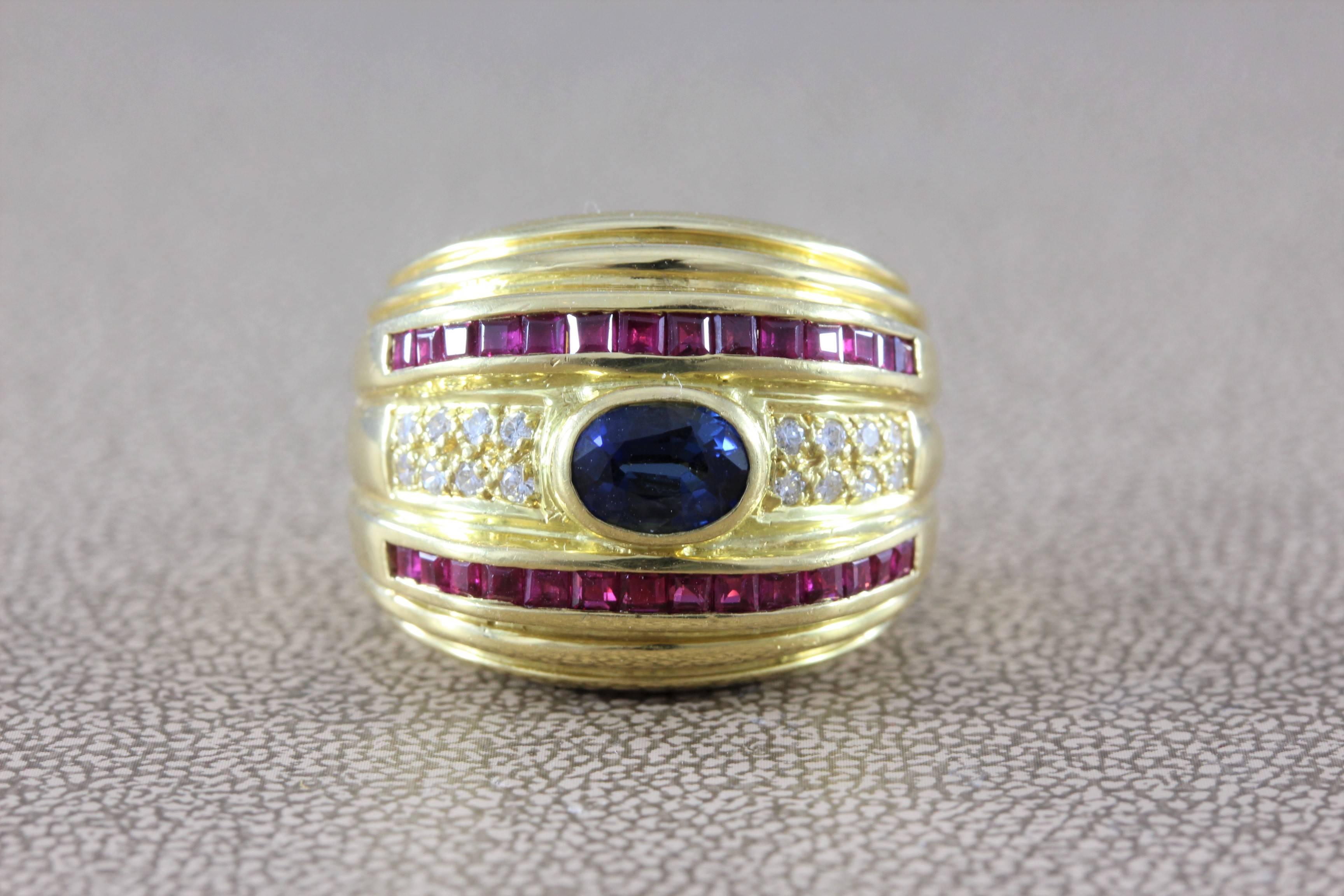 A vintage ring with a vibrant blue 0.80 carat sapphire center.  The oval cut sapphire is bezel set.  The fabulous ring is lined on both sides by 0.85 carats of deep red princess cut rubies.  0.15 carats of diamonds are set on both sides.  Set in 18K