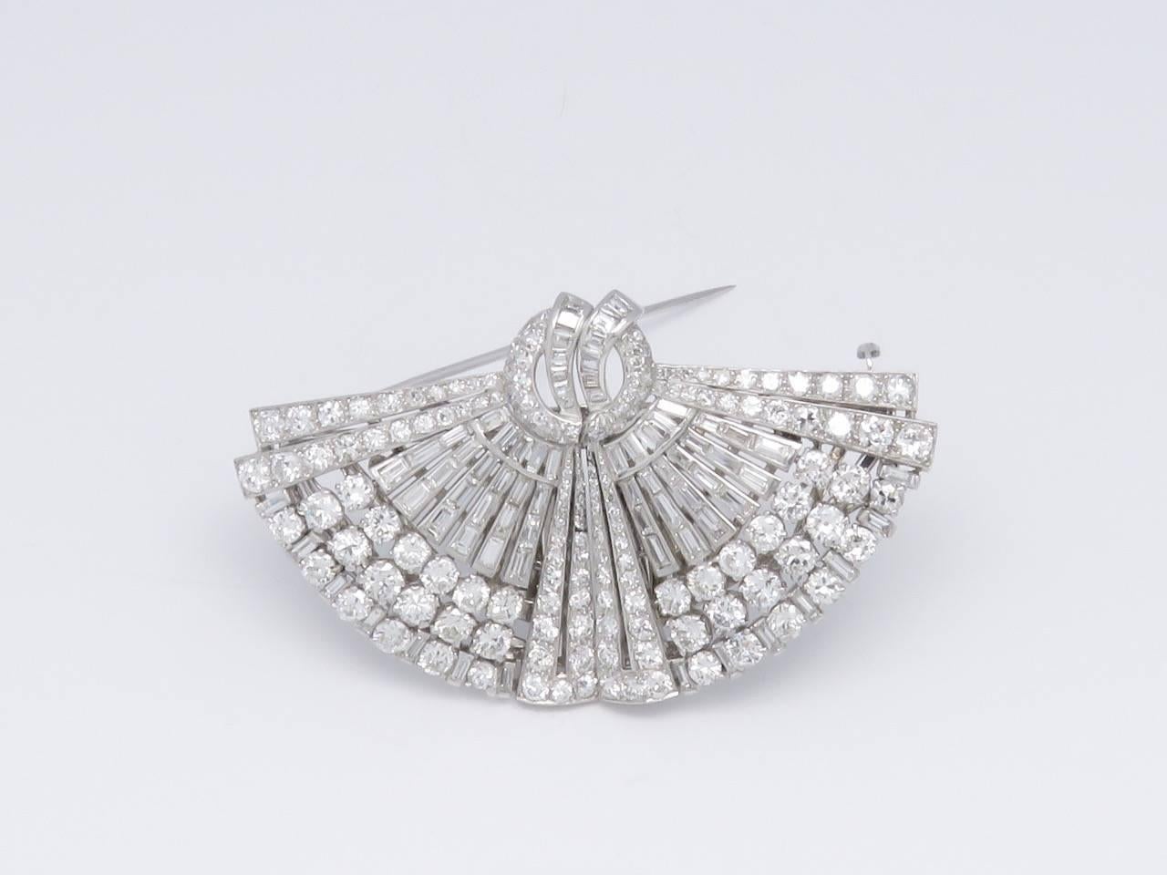 This clip brooch is convertible in two brooches.
The double clip brooch has round and baguette-cut diamonds with approximate total weight of 10.00 carats ( H/I color, Vs/Si clarity ).
An Art Deco diamond Double Clip Brooch by Drayson