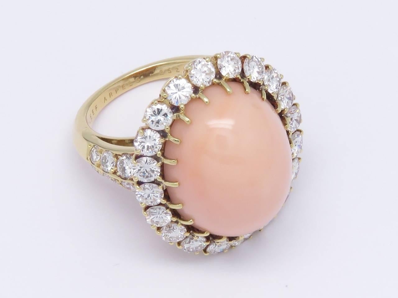 Set with a cabochon Coral Pink within a round brilliant diamond surround flanked to either side by six round brilliant diamonds.
Mounted in 18k yellow gold.
French assay marks for gold.
Circa 1970

Measurements:
Coral Cabochon: Approximately 0.83 in