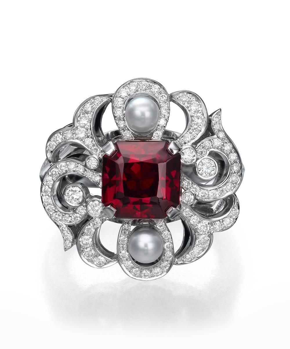 A stunning hand made one of a kind 2.90 Carat rectangular Garnet Stone is in the center of this exquisite ring. The luminous gem is perfectly complemented by Pearls and 138 round brilliant Diamonds.  
Presented in a sophisticated and classic white