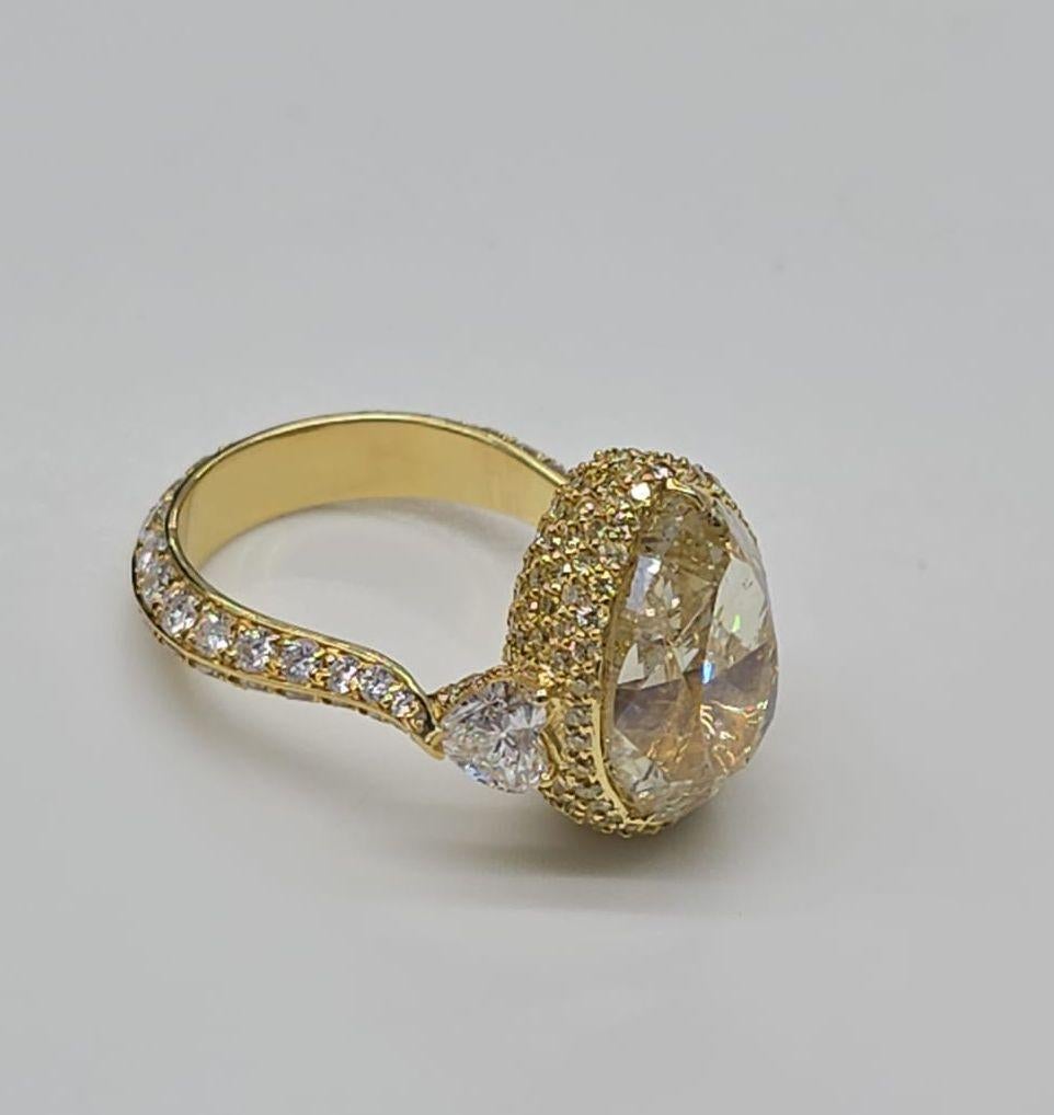 Preparati a rimanere incantato da questo squisito anello di fidanzamento con aloni in oro giallo 18 carati, una vera incarnazione di romanticismo ed eleganza. Al centro si trova un diamante mozzafiato di 14,37 Carati a forma di pera di colore giallo