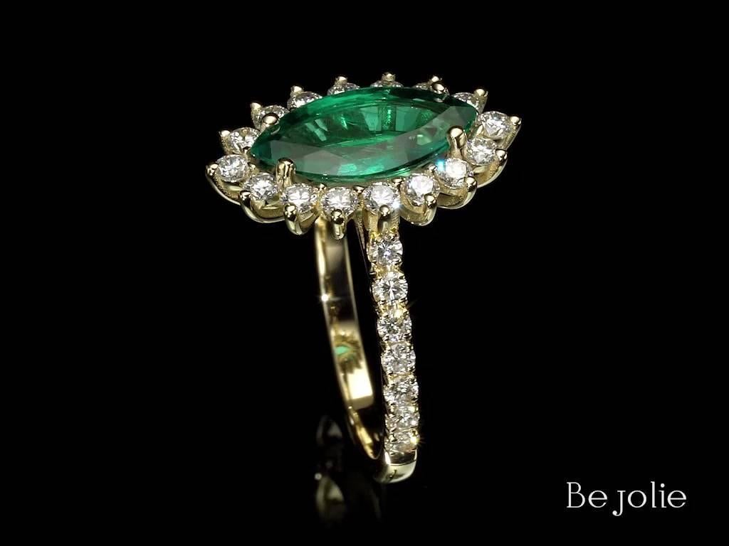 Handcrafted Emerald and Diamond ring starring a 1.90 Carat natural emerald. Our one of a kind Marquise cut emerald accompanies with 16 round brilliant cut diamonds 0.53 Carat Total Diamond Weight E-G VS and mounted on 18K yellow gold. 
Ring size is