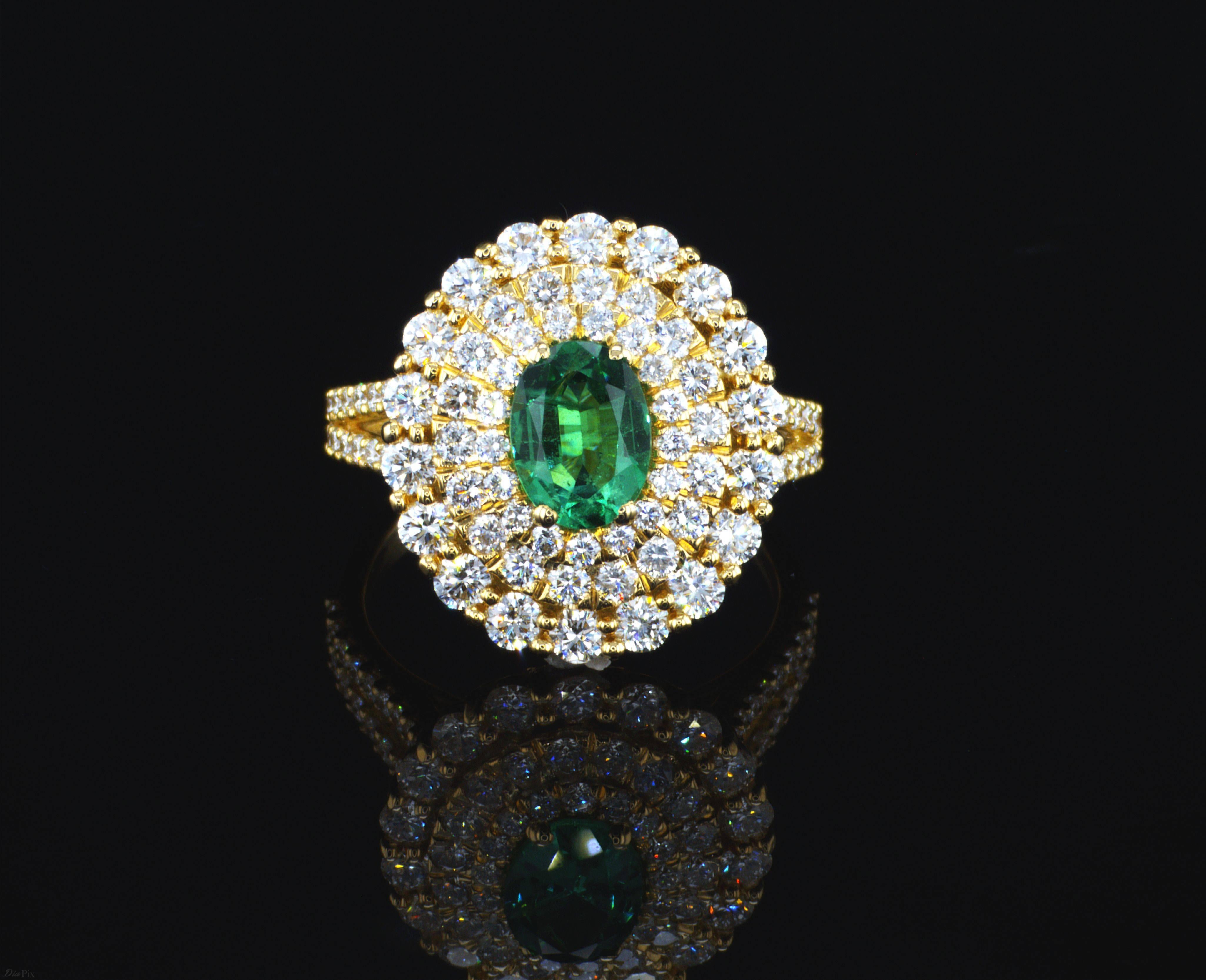One of a kind ring starring 0.80 Carat Oval Cut Natural Emerald encircled in a triple halo white round diamonds. This Hand crafted ring is done with precise workmanship and set on 18K Yellow Gold. 
Jewel Details: 
0.80 Carat Oval Natural Emerald
90