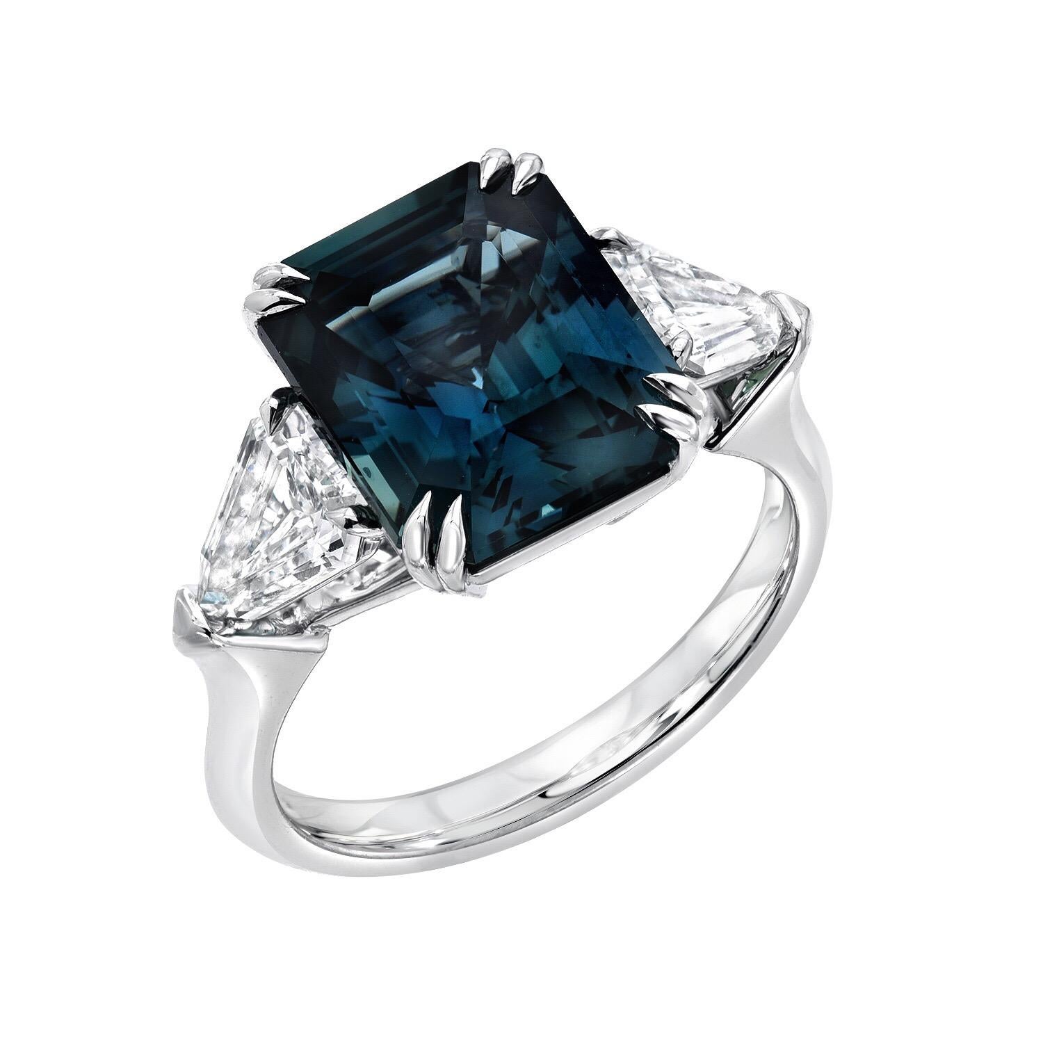 Natural, no heat Sapphire 6.07 carat, emerald cut, platinum ring, displaying a most unique teal, greenish blue color, and is flanked by a pair of shield shaped diamonds E/VS, weighing a total of 1.10 carats.
The GIA certificate is attached to the