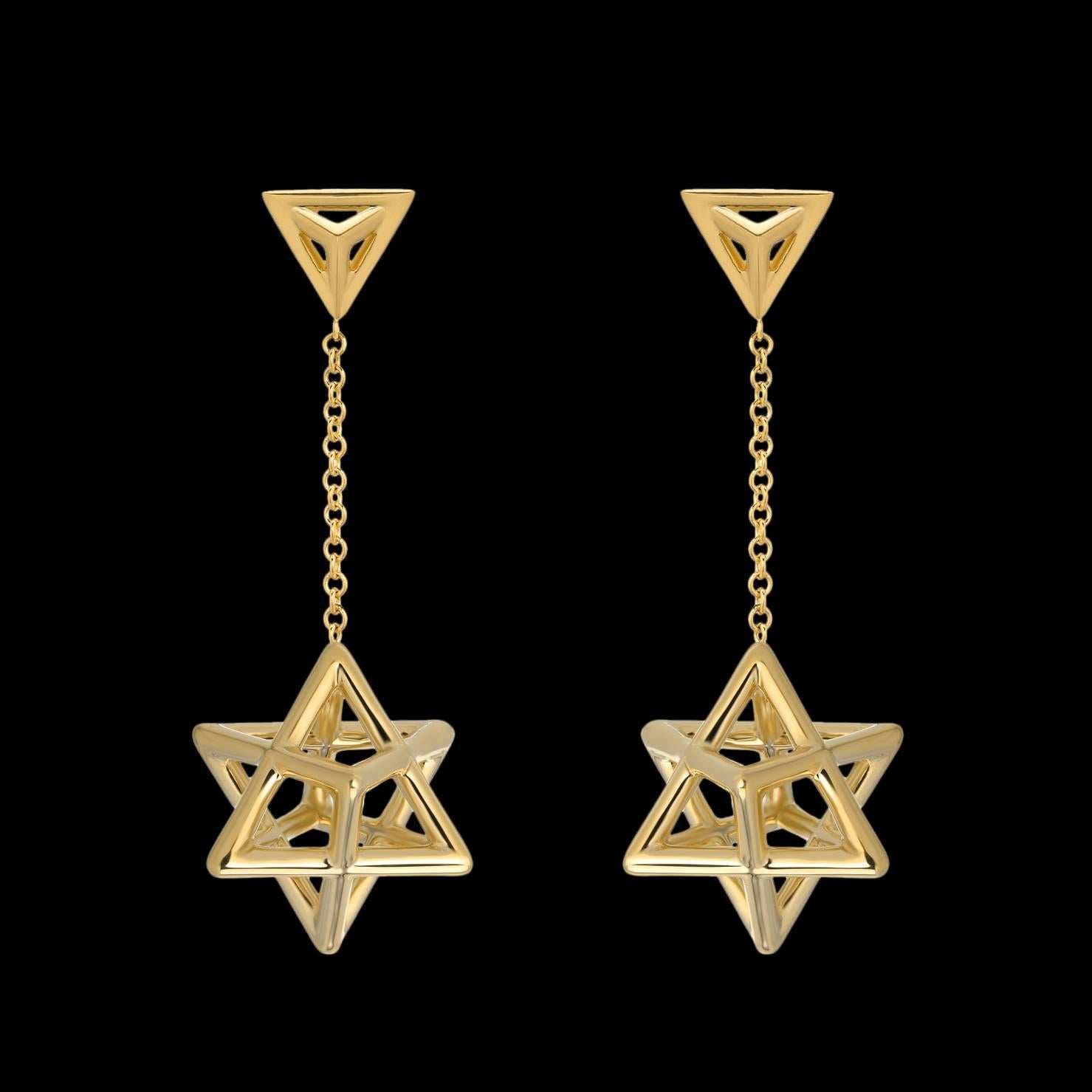 Merkaba 18K yellow gold drop earrings, tethered by a triangle stud, feature a chain suspending a three dimensional Merkaba Star of David, measuring 0.57 inches. Secure La Pousette ear backs mirror the triangle motif. 
Total length -1.5 inches.
Each