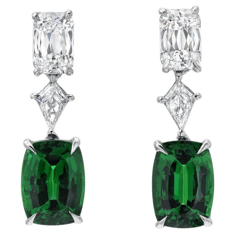 Rare vivid green pair of cushion cut Tsavorite Garnets weighing a total of 3.26 carats, are set in these remarkable 1.31 carat total diamond earrings.
The fancy-cut elongated cushion-shaped diamond pair on top, weigh a total of 1.03 carats, and are