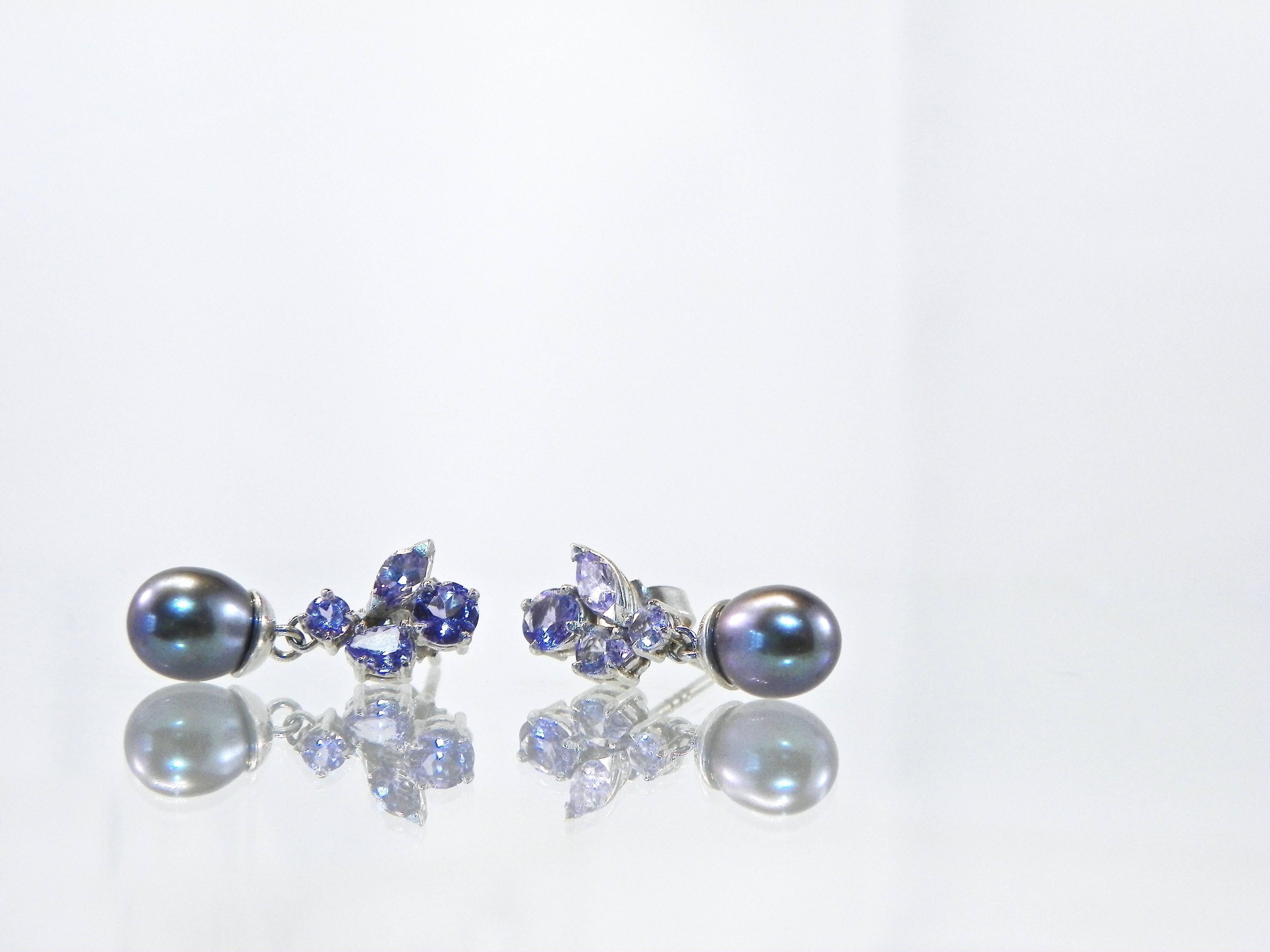 These lovely modern yet classic tanzanite 14K white golden pearl drops earrings sparkle and are a must have for every jewelry collection.
Each earring has 0.60 ct round, pear and marquise shaped sparkly lavender blue  purplish tanzanites. 
Each