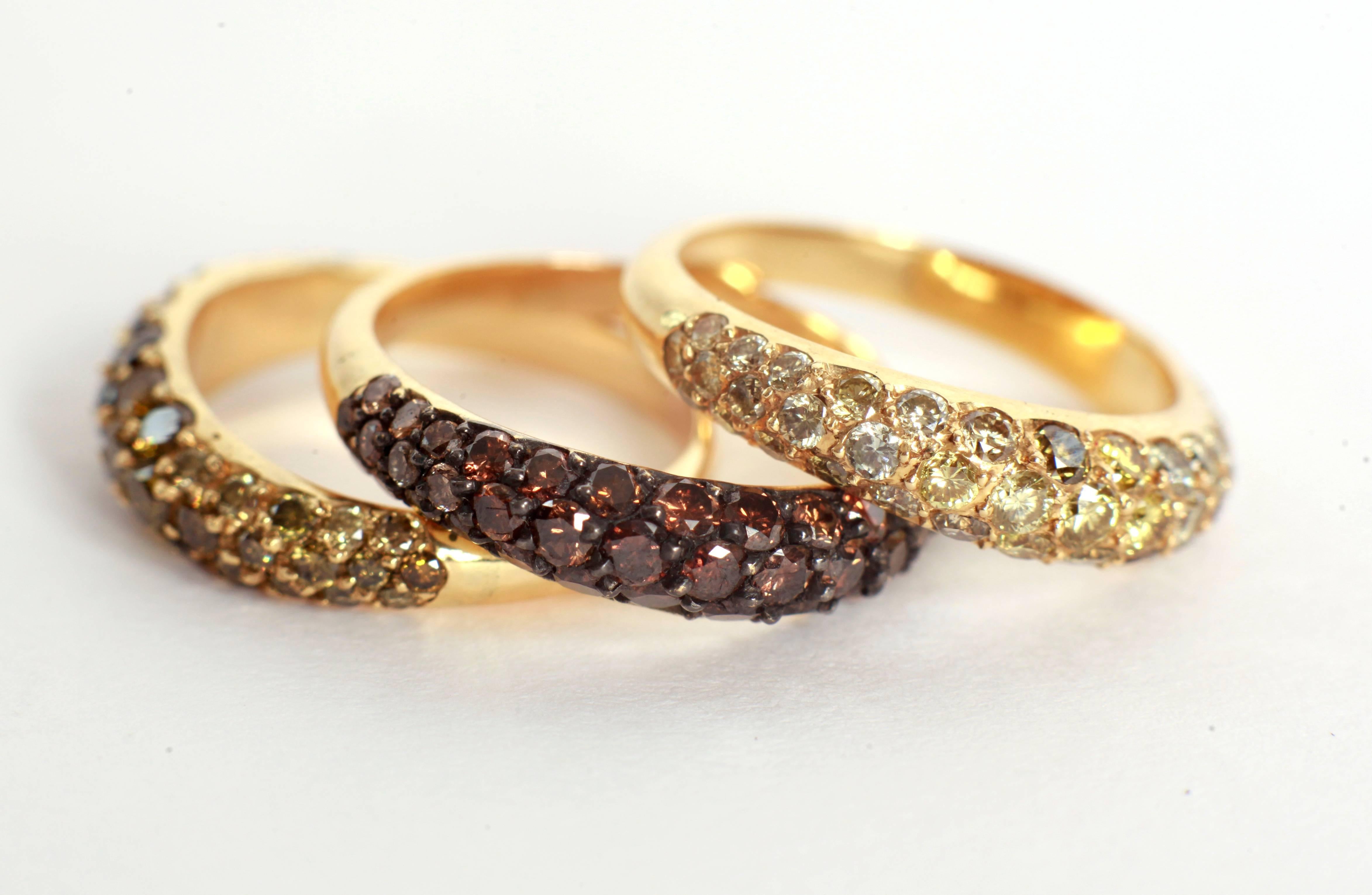 These three lightly wavy pave-set band rings are composed by:
- A yellow diamond pave-set with a subtil yellow graduation colour, 18K gold
-A chocolate diamond pave-set with a subtil brown graduation colour, 18K gold
- A green diamond pave-set with