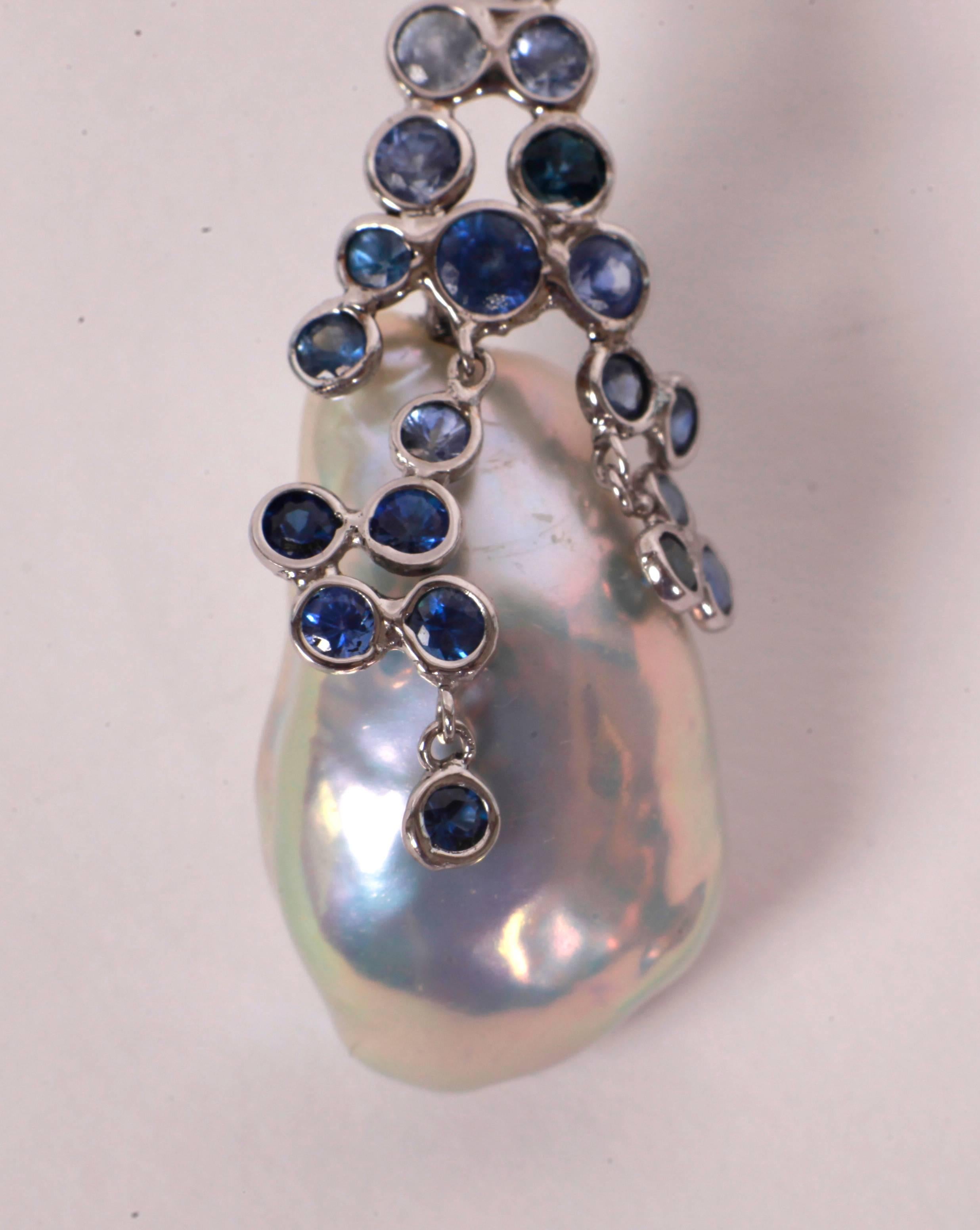 Drops of sapphire dew surrounding two white-blue baroque  pearls. The sapphires bring freshness to the pearls.  The inside of its shell is white and bluish white. They are spectacular!
18k white gold, Alpa security system 
Sapphires weight: 4.80