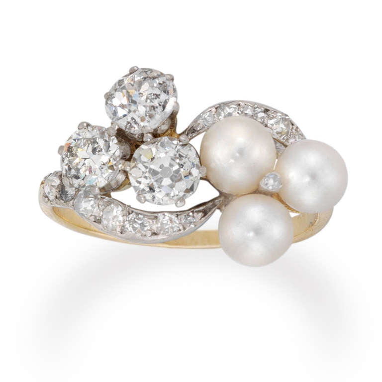 A Victorian double trefoil pearl and diamond ring, set in white with three round pearls each measuring approximately 5x5 mm and three old brilliant-cut diamonds estimated to weigh a total of 1.3 carats all to a yellow gold mount with diamond-set