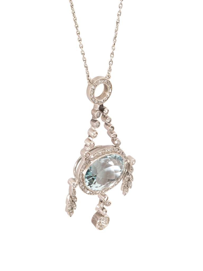 An important turn-of-the-century Fabergé aquamarine and diamond pendant, the pendant comprising an oval faceted aquamarine, within a diamond-set border, with three diamond foliate drops, with diamond surmount and chain, Purchased by dowager Empress