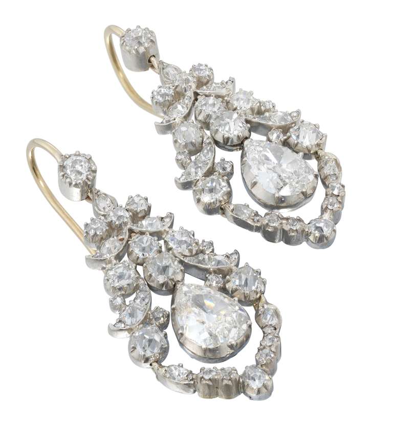 A pair of late Georgian open-work diamond drop earrings, set with three graduating old brilliant-cut diamonds, the principal pear shaped diamonds weighing approximately 3.5 carats the pair, suspended from two old brilliant-cut diamonds within a