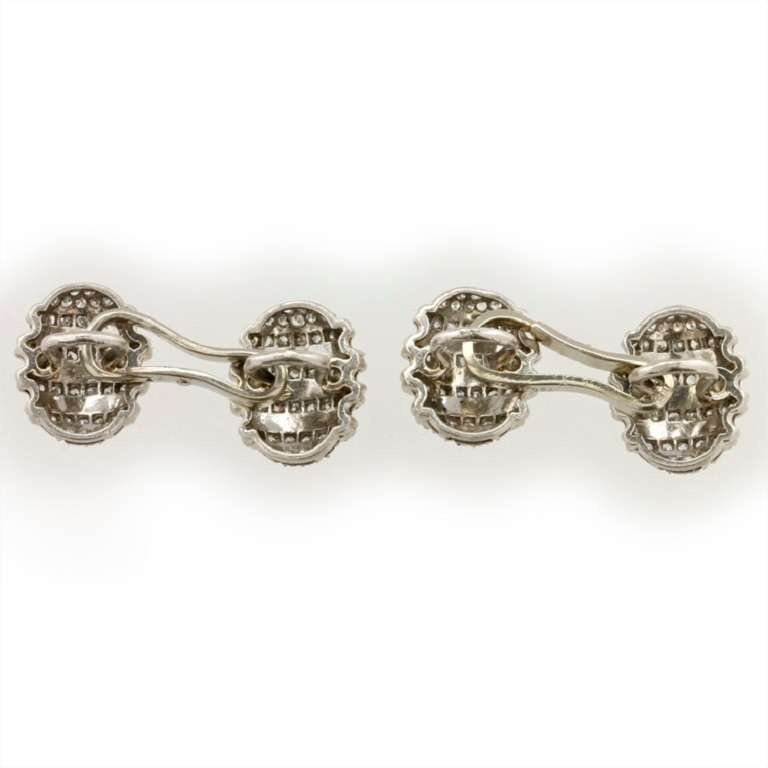 Ein Paar diamantbesetzte ovale gewölbte Manschettenknöpfe, mit acht diamantbesetzten Streifen, die abwechselnd in eine Fassung aus 18 Karat Weißgold gefasst sind, um 1930.
Bruttogewicht 9,9 Gramm