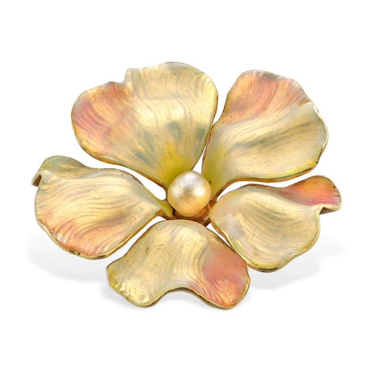 A late Victorian enamel and pearl flower brooch, the finely modelled petals in shaded yellow and pink opalescent enamel, embellished with a natural seed pearl cluster to the centre, to a yellow gold mount with brooch fittings, measuring