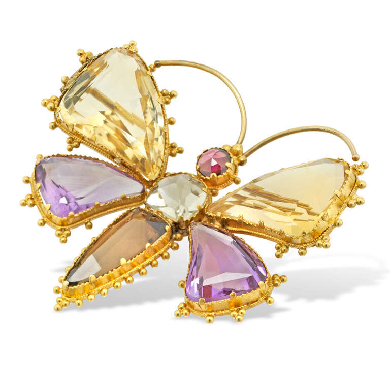 A Victorian yellow gold and gemset butterfly brooch, the butterfly comprising amethyst and citrine-set double wings, with citrine body and garnet head, all set to a yellow gold mount with beaded decoration to the sides, gross weight 7.8 grams, circa