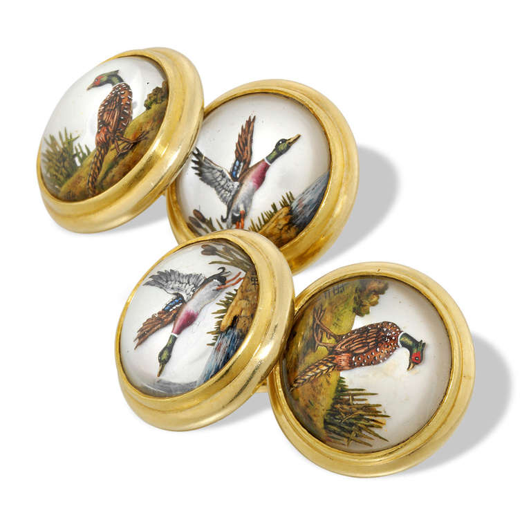 A pair of circular reverse carved crystal intaglio cufflinks, depicting mallards and pheasants, painted on mother of pearl, 1.4cm wide, all mounted in yellow gold stamped 750, continental, circa 1910.