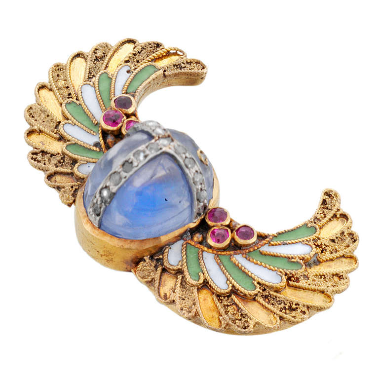 An antique Egyptian revival scarab brooch, the cabochon-cut sapphire in a rub-over setting with rose cut diamond details, the outstretched curved wings with green and white enamel work and rubies, all in 14ct yellow gold, bearing the hallmarks for