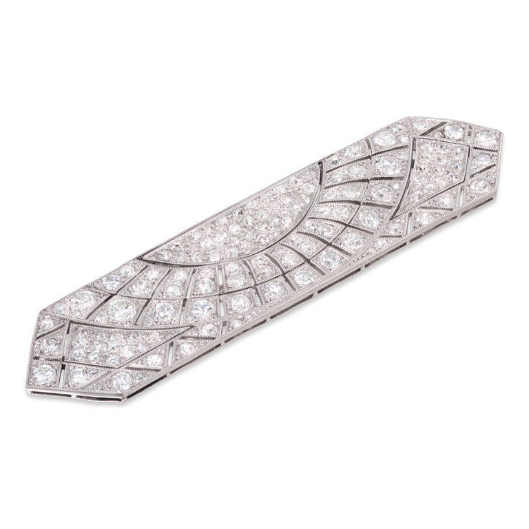 An Art Deco rectangular sunburst diamond brooch, the brooch of an open-plaque design with pointed ends, set throughout with old brilliant-cut diamonds, estimated to weigh a total of 6 carats, set to a pierced platinum mount and brooch fitting, circa