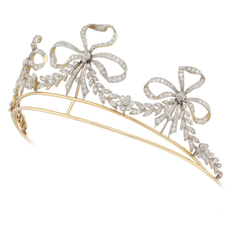 An early 20th century American diamond scroll tiara, the tiara comprising three ribbon bow motifs, with garland swags in between, set throughout with old-cut diamonds, all set in silver to a yellow gold mount and frame, stamped 35365, bearing the