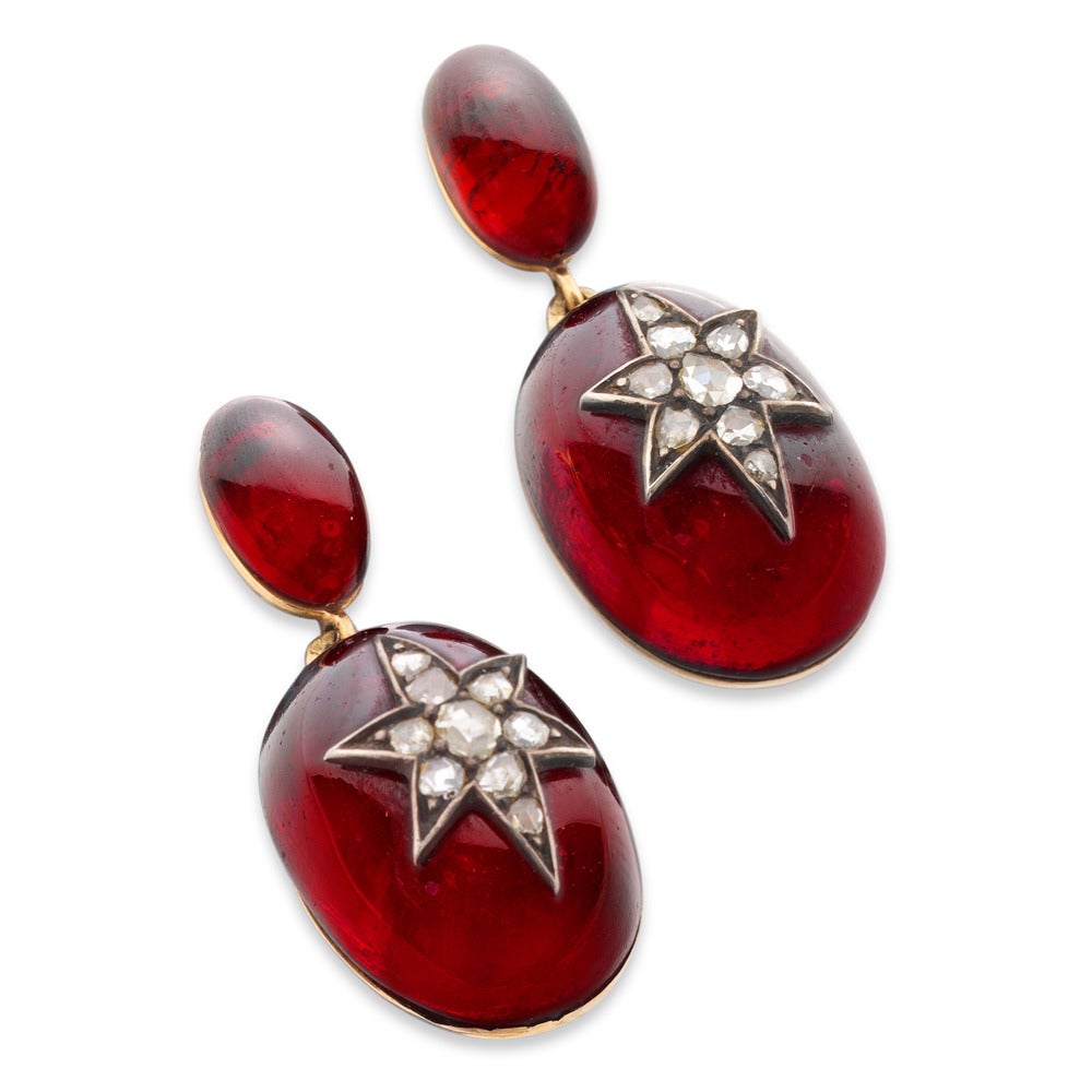 A pair of Victorian Garnet with two oval cabochon garnet drops the larger applied with a diamond-set star motif, circa 1860.
