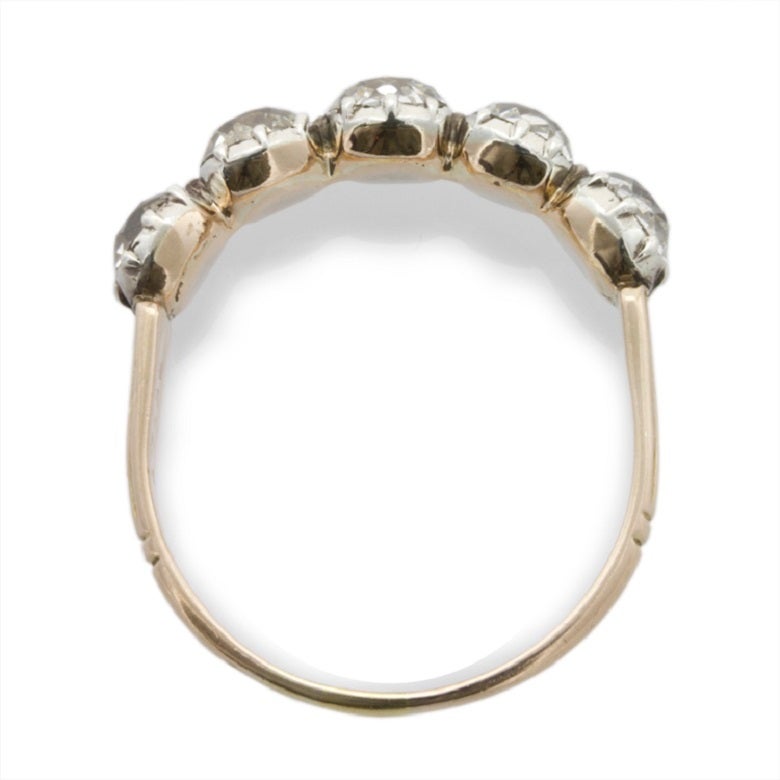 A Georgian diamond five stone ring, the five old brilliant-cut diamonds weighing approximately 2.20 carats all in a silver cut-down setting to a closed back gold mount with engraved reeded design shoulders, circa 1780, gross weight 2.6 grams,