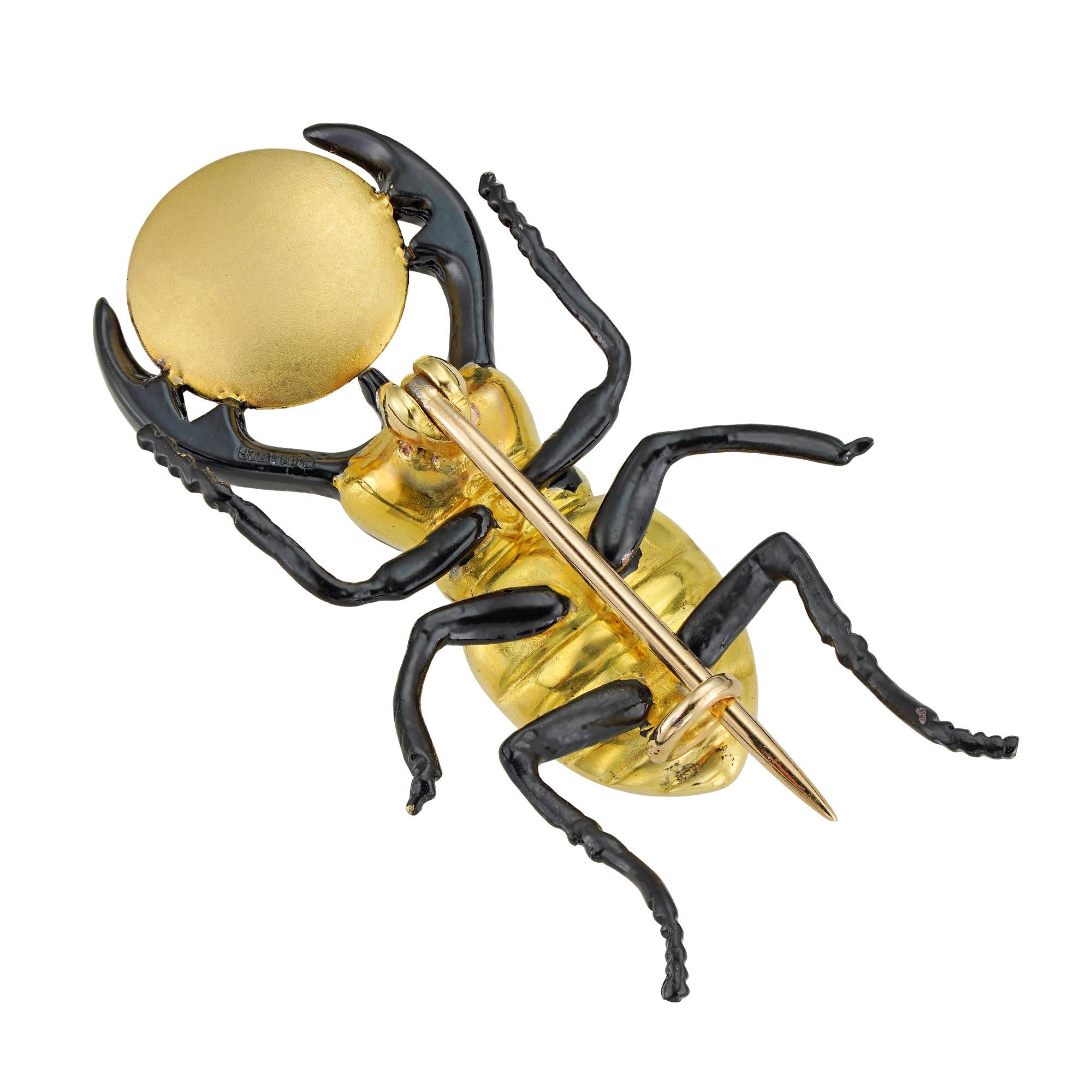 Skarabäuskäfer/Ra-Khepri-Brosche aus Gold und schwarzer Emaille. Der goldene Körper des Käfers ist mit Beinen und Augen aus schwarzer Emaille verziert, die Mandibeln halten eine mattgoldene Scheibe, montiert an einem Broschenbeschlag, gepunzt auf 18