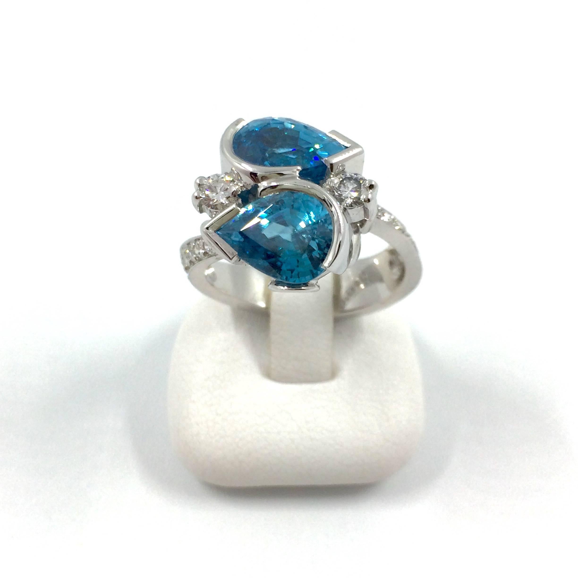 A white gold ring set with two pear cut blue zircon surrounded by 14 brilliant cut diamonds. This bypass ring is a unique creation entirely handmade.
Total Zircon Weight: 7,75 carat
Origin of the zircon: Cambodia
Total Diamonds Weight: 0,78