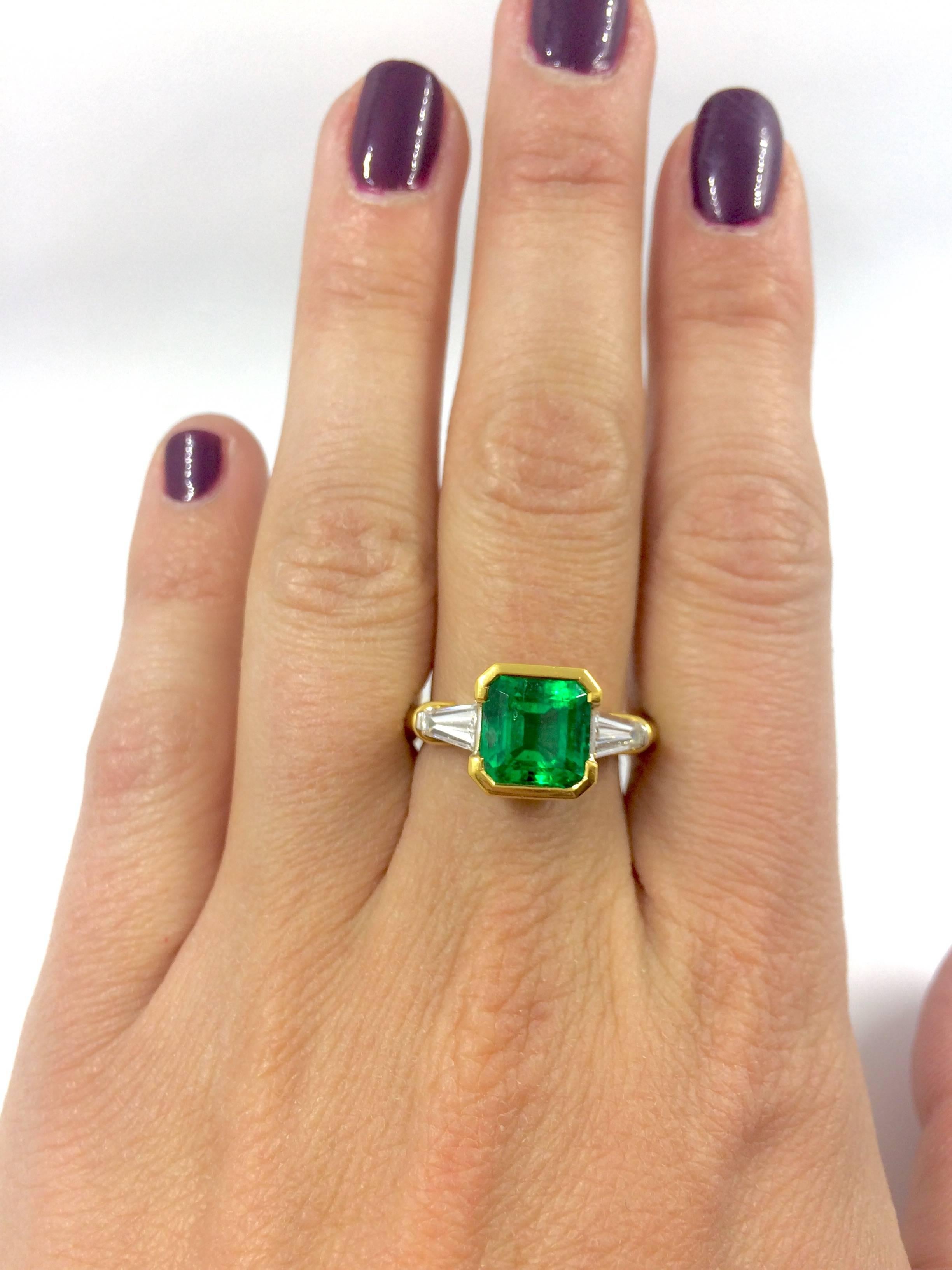 A white and yellow gold ring set in the middle with a stunning colombian square cut emerald, surrounded by a trapeze cut diamond on each side.
Under the emerald there is a brilliant cut diamond set on each side.
The ring is a unique creation