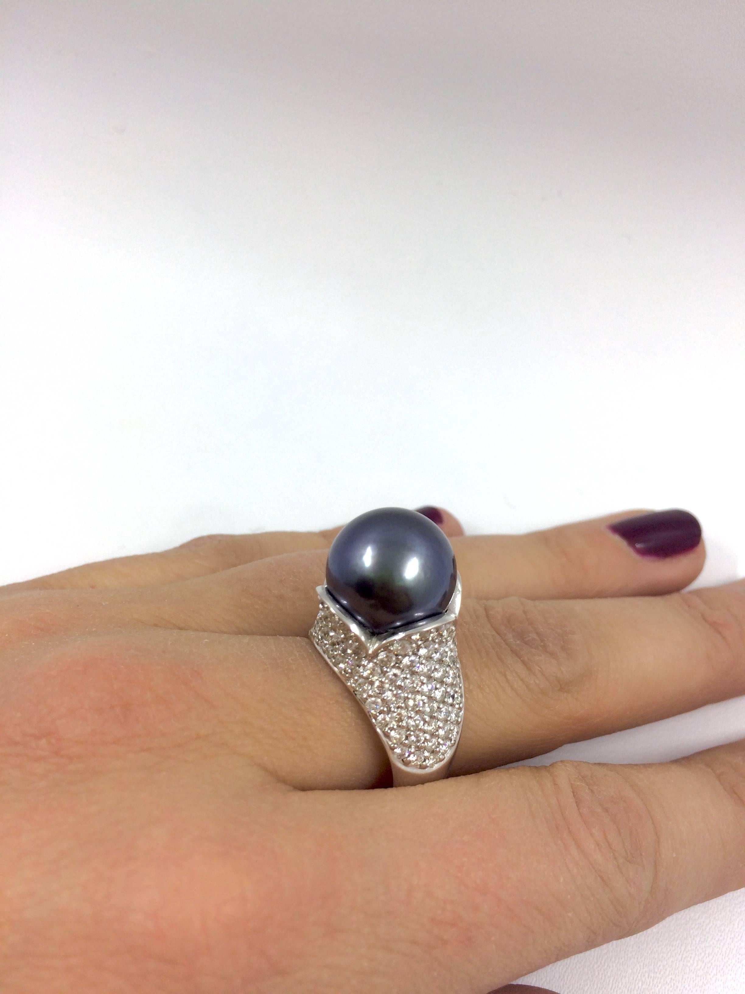 A white gold ring set with a tahitian pearl in the center and 2,36 carat of brilliant cut diamonds surrounding the pearl.  
Pearl diameter : 13 mm  
Quality : AAA, beautiful luster and brilliancy. 
Net Weight: 11,19 grams
Finger Size: 7 (can be